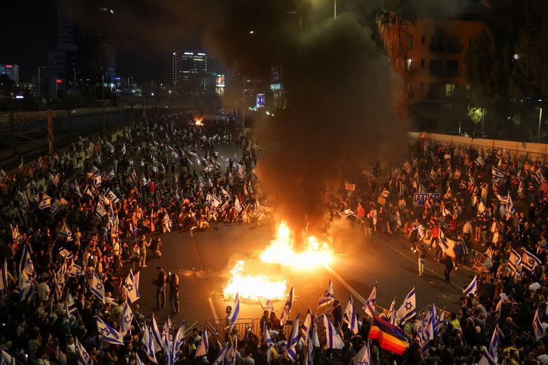 Arde fuego mientras la gente asiste a una manifestación contra Netanyahu en Tel Aviv, Israel, 27 de marzo de 2023. (REUTERS/Nir Elias)