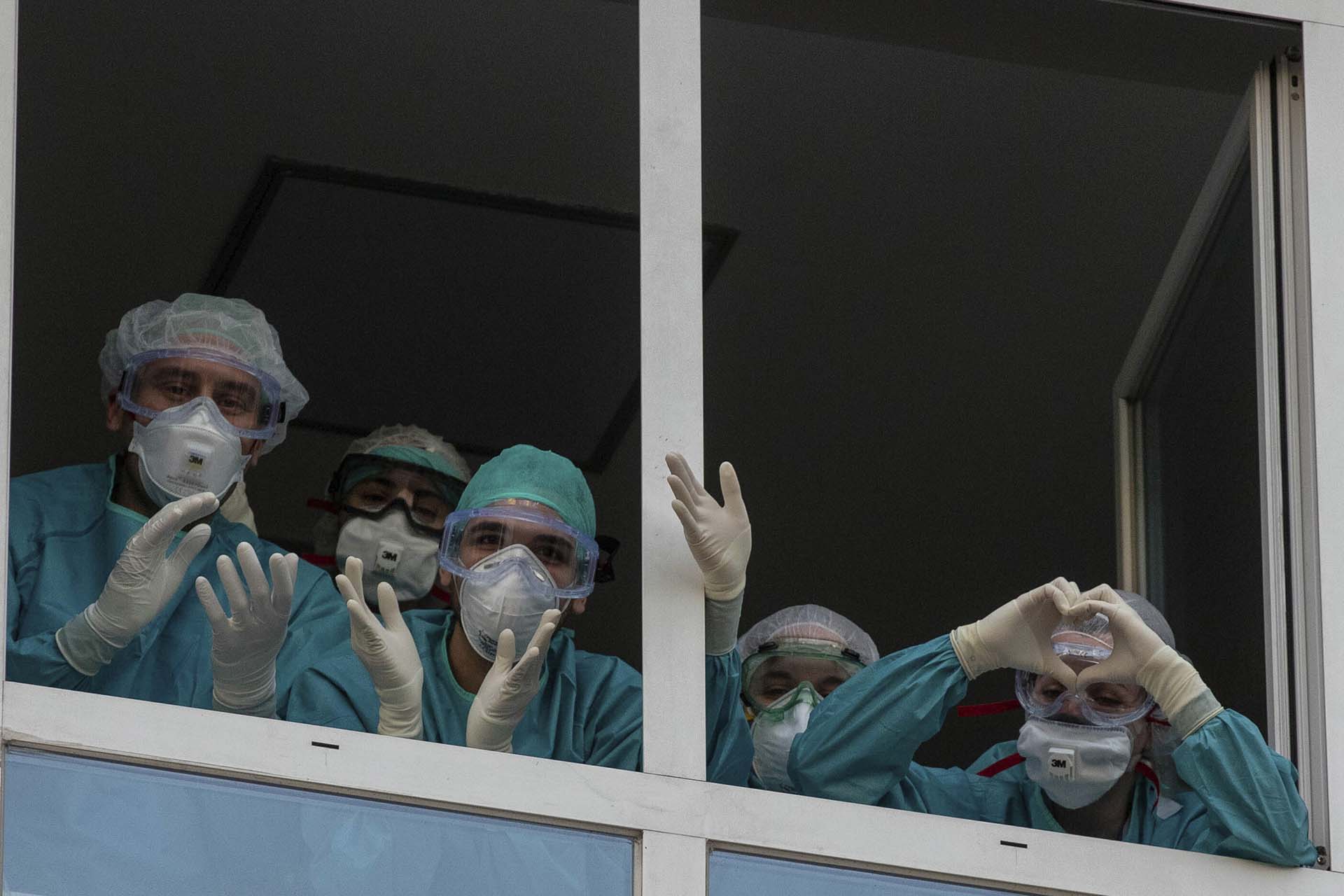 Trabajadores de la salud reaccionan a los aplausos de quienes les agradecen por su trabajo en la Fundación Universitaria Jimenez Diaz en Madrid, España (AP Photo/Manu Fernandez)