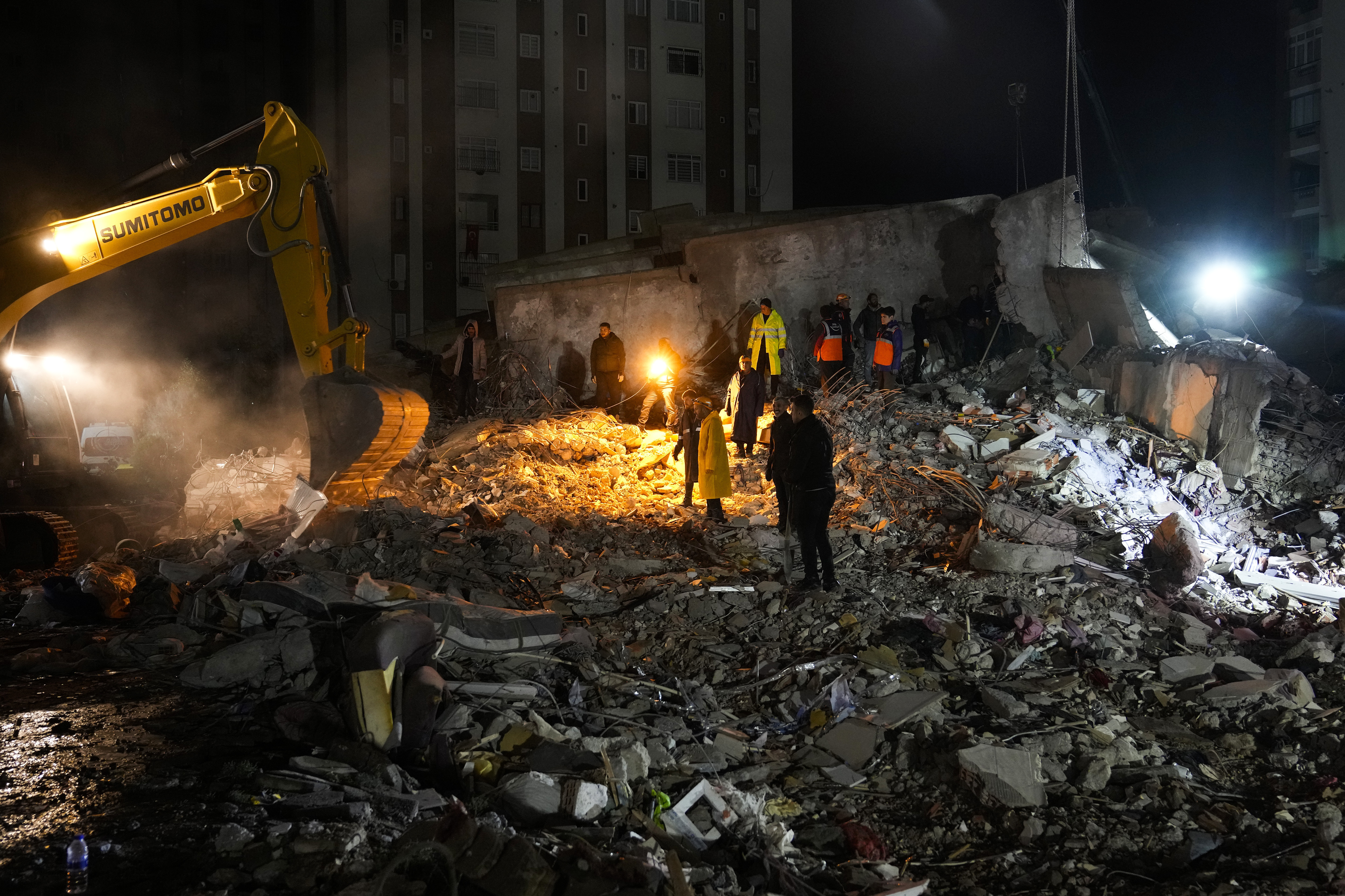 Equipos de emergencia buscan personas entre los escombros de un edificio destruido en Adana, Turquía (AP Foto/Khalil Hamra)