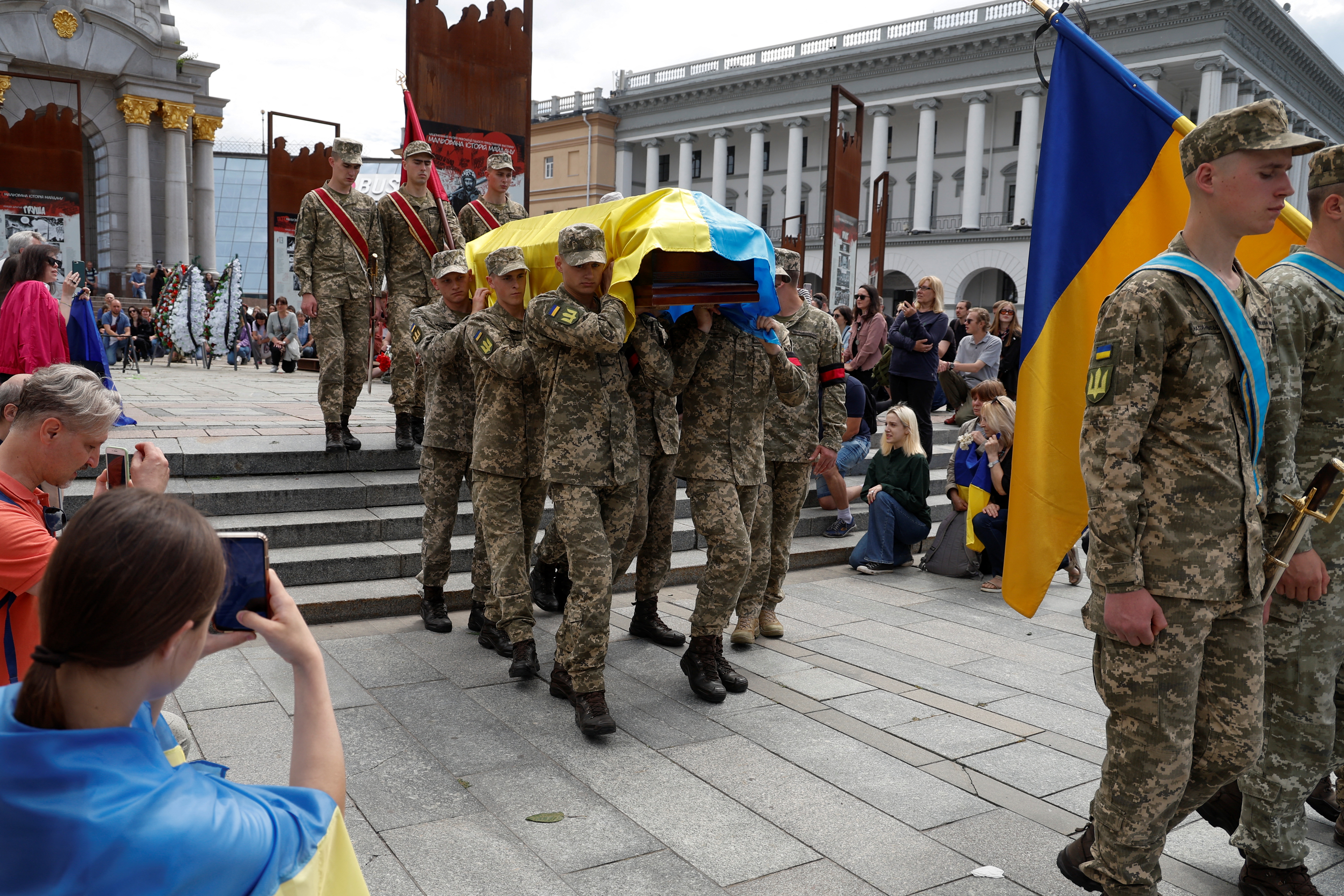 Miembros de la Guardia de Honor llevan un féretro con el cuerpo de Roman Ratyshnyi, un activista público ucraniano y miembro del servicio, que murió recientemente en una batalla contra las tropas rusas, en la Plaza de la Independencia en Kiev, Ucrania 18 de junio de 2022.  REUTERS/Valentyn Ogirenko