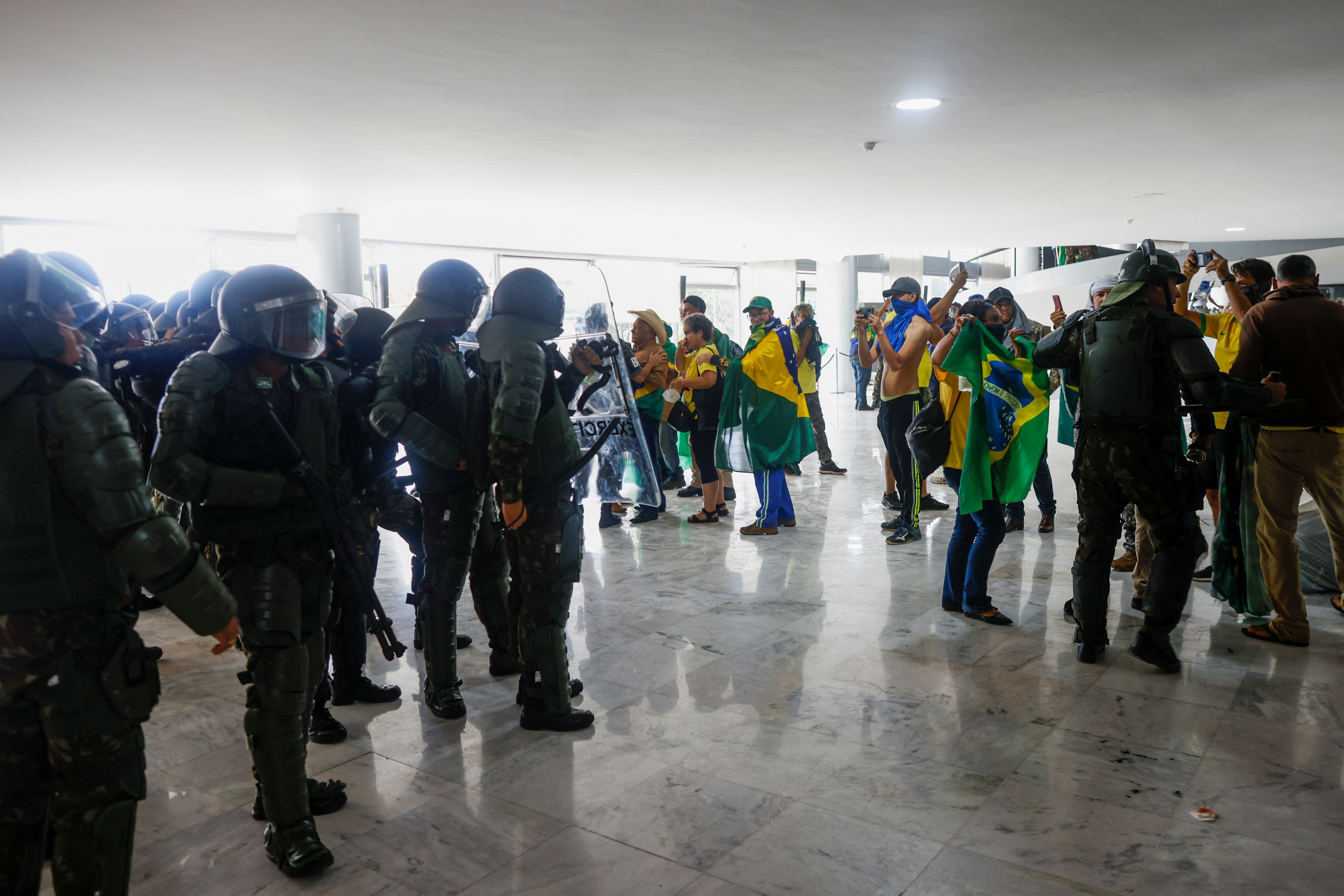 Policías y manifestantes bolsonaristas en Planalto, Brasilia, durante el ataque a los edificios del gobierno (Reuters)