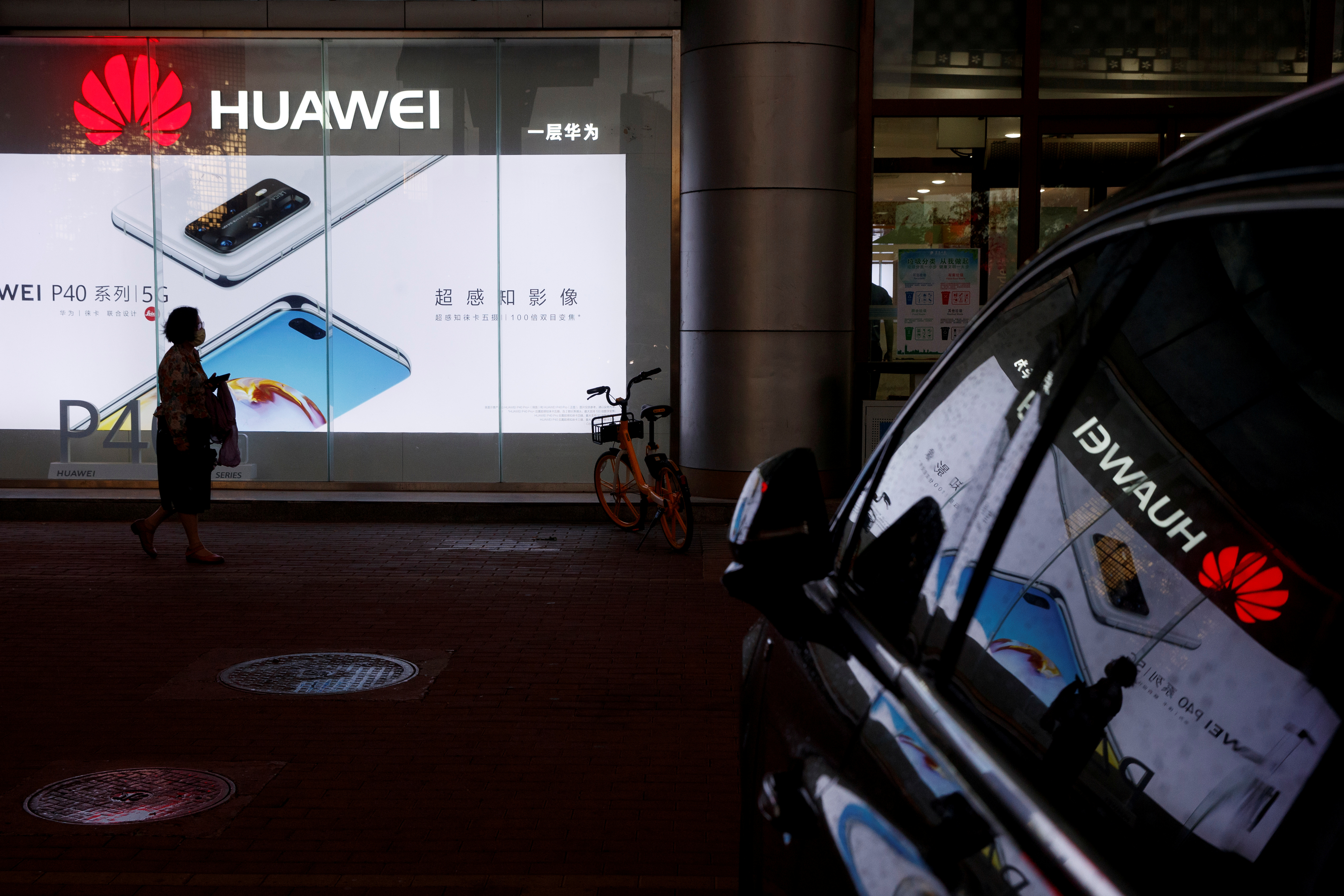 Una mujer pasa frente a una tienda Huawei en Beijing, China, el apsado 28 de mayo (Reuters)