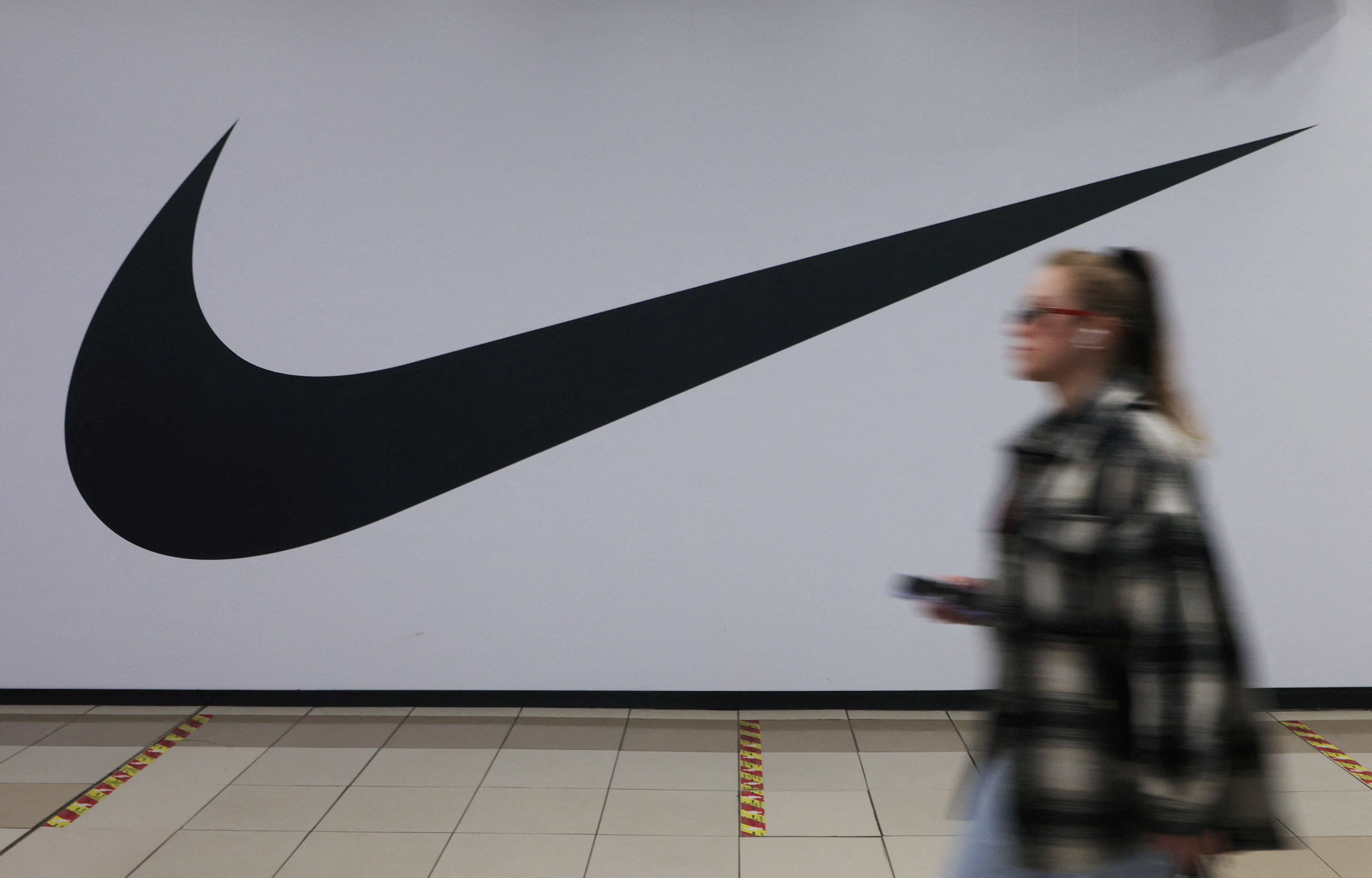 Una mujer pasa por delante de una tienda cerrada del minorista de artículos deportivos Nike en un centro comercial en San Petersburgo (REUTERS/Anton Vaganov)