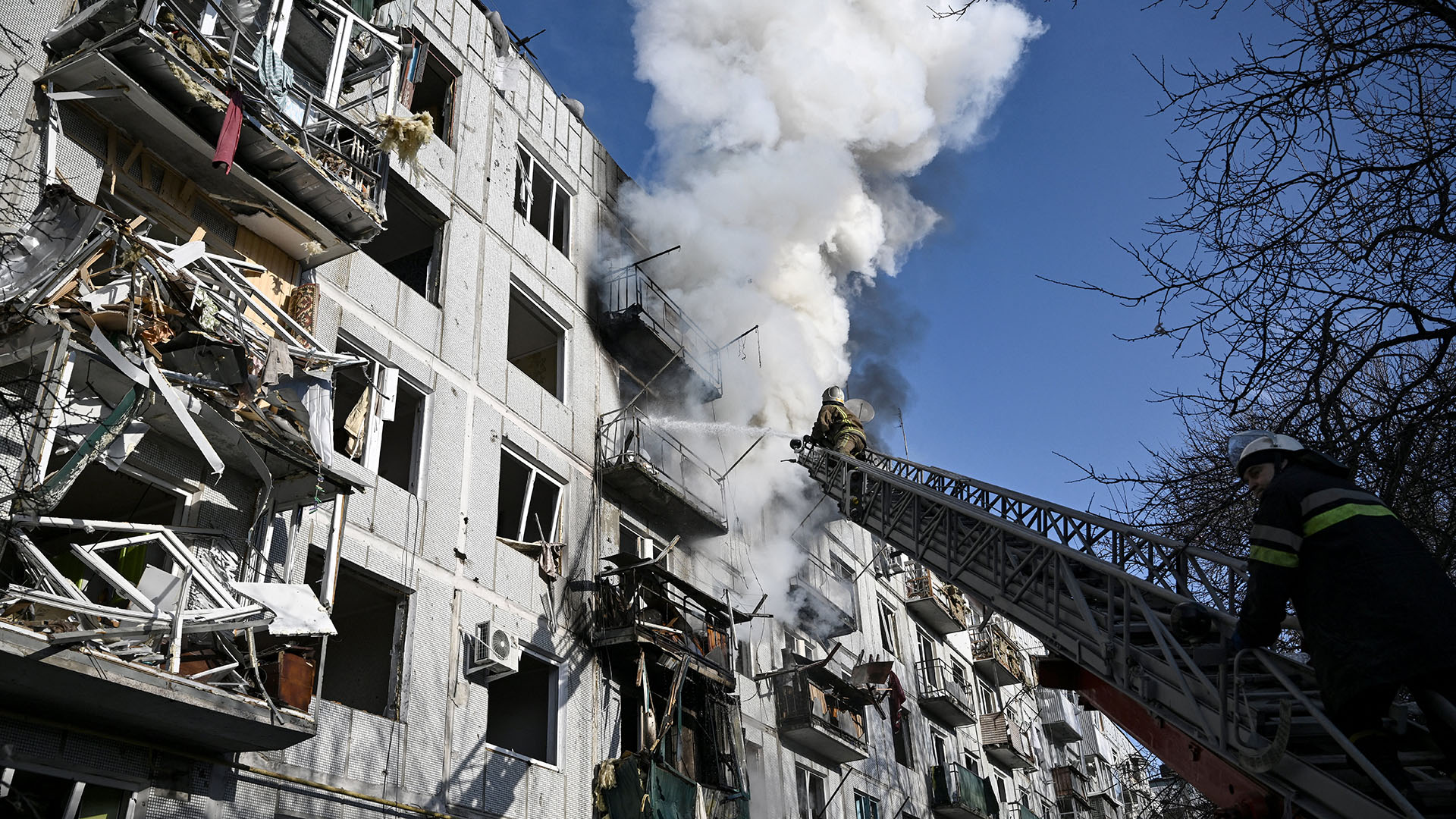 Los bomberos trabajan en un incendio en un edificio después de los bombardeos en la ciudad de Chuguiv, en el este de Ucrania, el 24 de febrero de 2022 (Foto de Aris Messinis / AFP)
