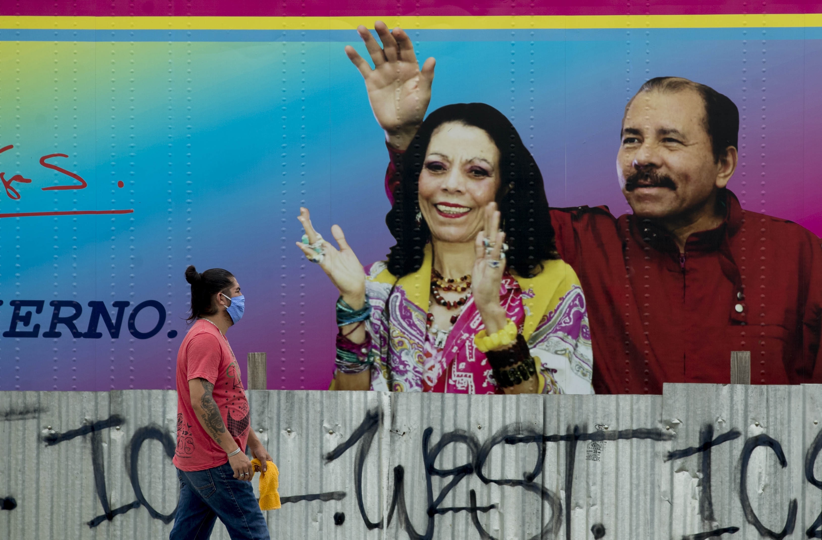 Una persona camina delante de un cartel de propaganda de Daniel Ortega y su esposa (EFE/Jorge Torres)