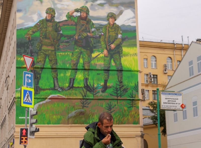 FOTO DE ARCHIVO. Un hombre fuma mientras pasa por delante de un mural, que fue pintado en un edificio en apoyo al ejército ruso (REUTERS/Evgenia Novozhenina)