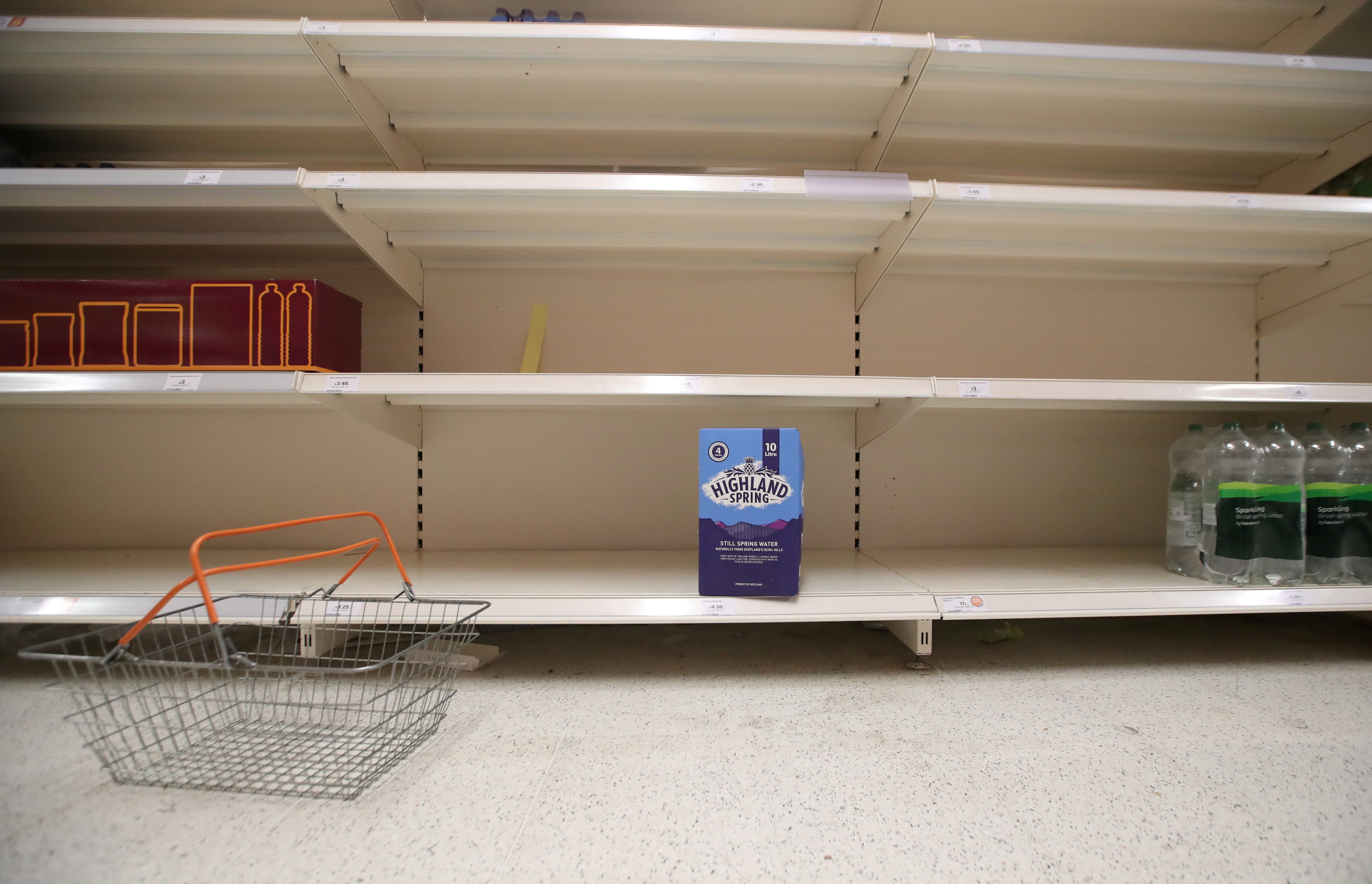 Una cesta de la compra  junto a los estantes vacíos del pasillo de refrescos, en el supermercado Sainsbury's en Harpenden, Gran Bretaña (Foto: Reuters)