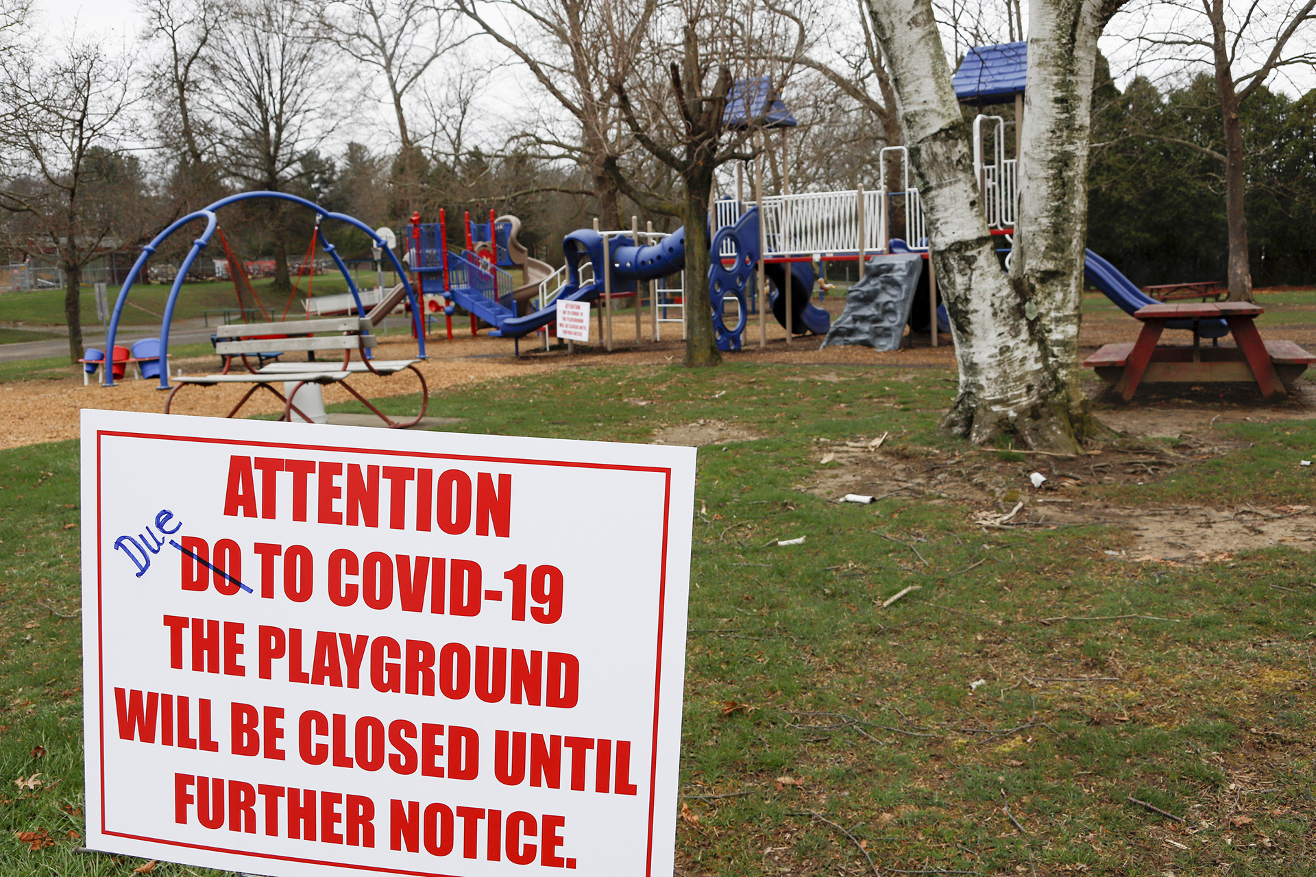 Un cartel con una falta de ortografía corregida avisa del cierre de un parque comunitario hasta nuevo aviso por el COVID-19, la enfermedad causada por el coronavirus, el 27 de marzo de 2020, en Zelienople, Pensilvania. (AP Foto/Keith Srakocic)