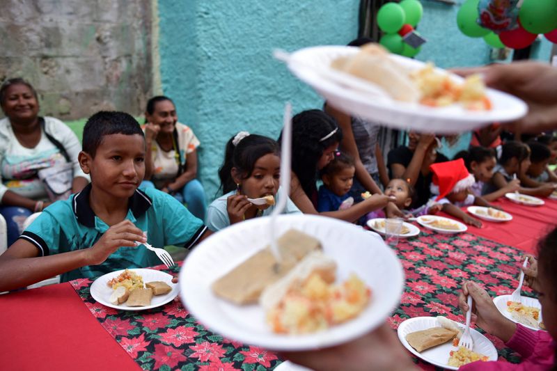 Niños Commen "Harakas"un plato tradicional local, durante una actividad navideña organizada en Caracas (REUTERS/Gaby Oraa/Archivo)