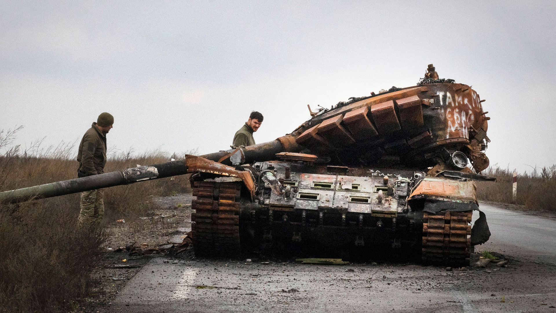 Soldados ucranianos inspeccionan un tanque ruso dañado en una carretera cerca de la aldea recientemente recuperada de Kamianka, región de Kharkiv, Ucrania, el domingo 30 de octubre de 2022. (Foto AP/Efrem Lukatsky)

