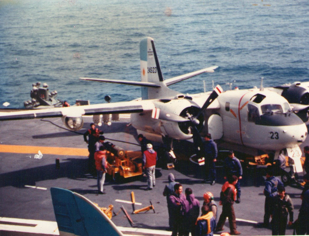 El Tracker 2-AS-23, rodeado de personal de cubierta del portaaviones, es armado con una bomba de profundidad.