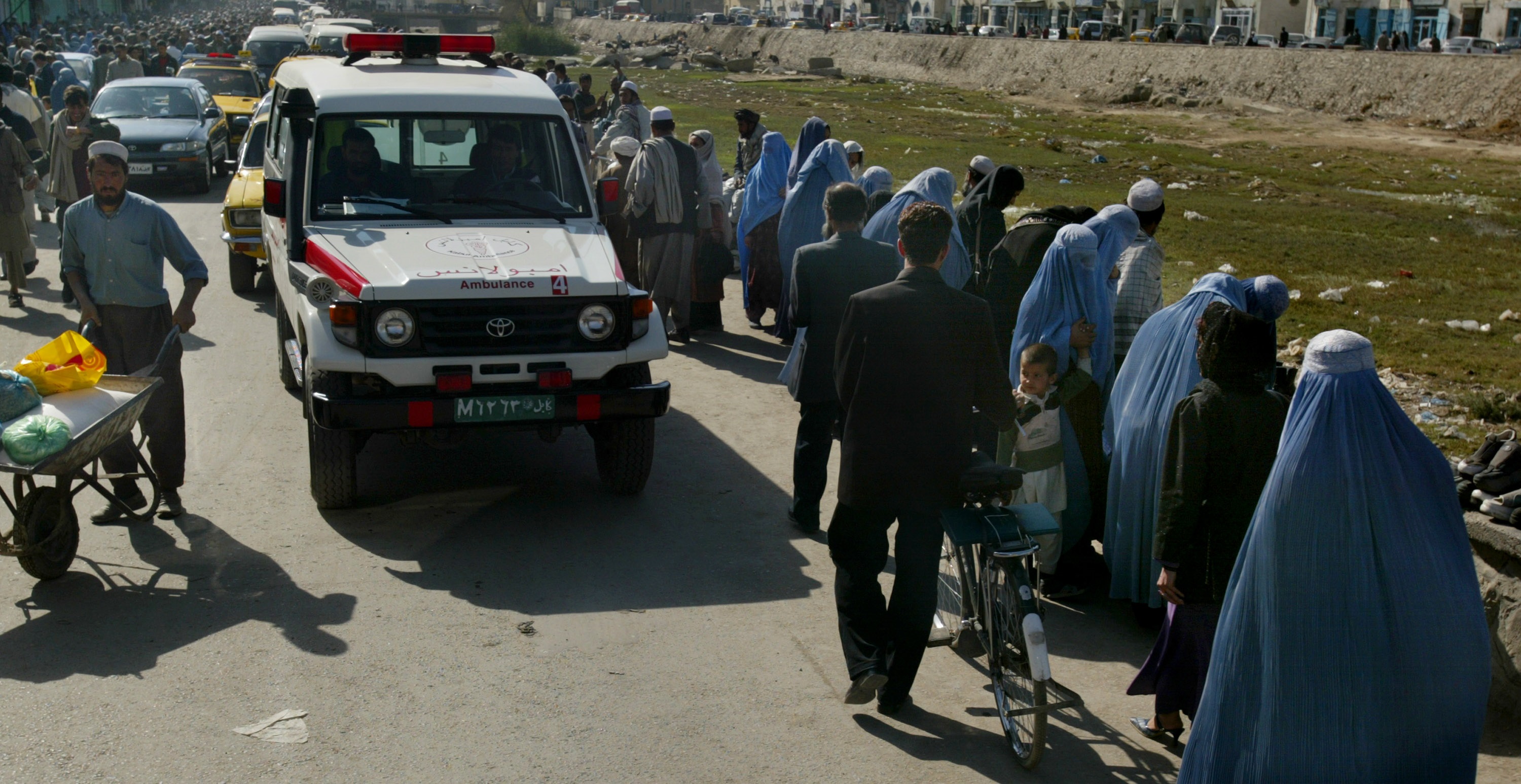 Una ambulancia junto a una fila de mujeres con burka en Kabul, Afganistán (Foto: Europa Press)