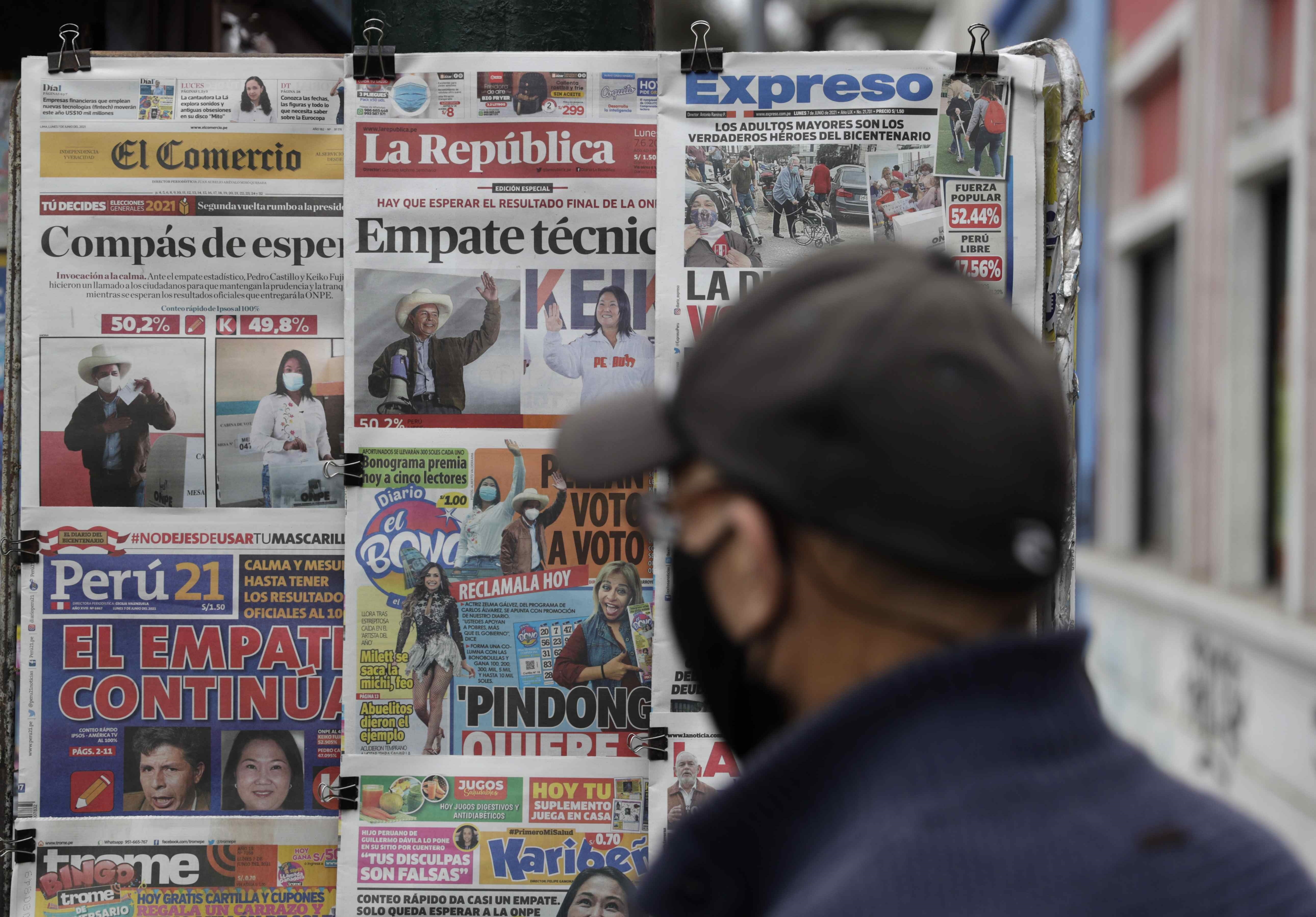 Una persona revisa las portadas de los periódicos hoy, en Lima (Perú). EFE/Paolo Aguilar