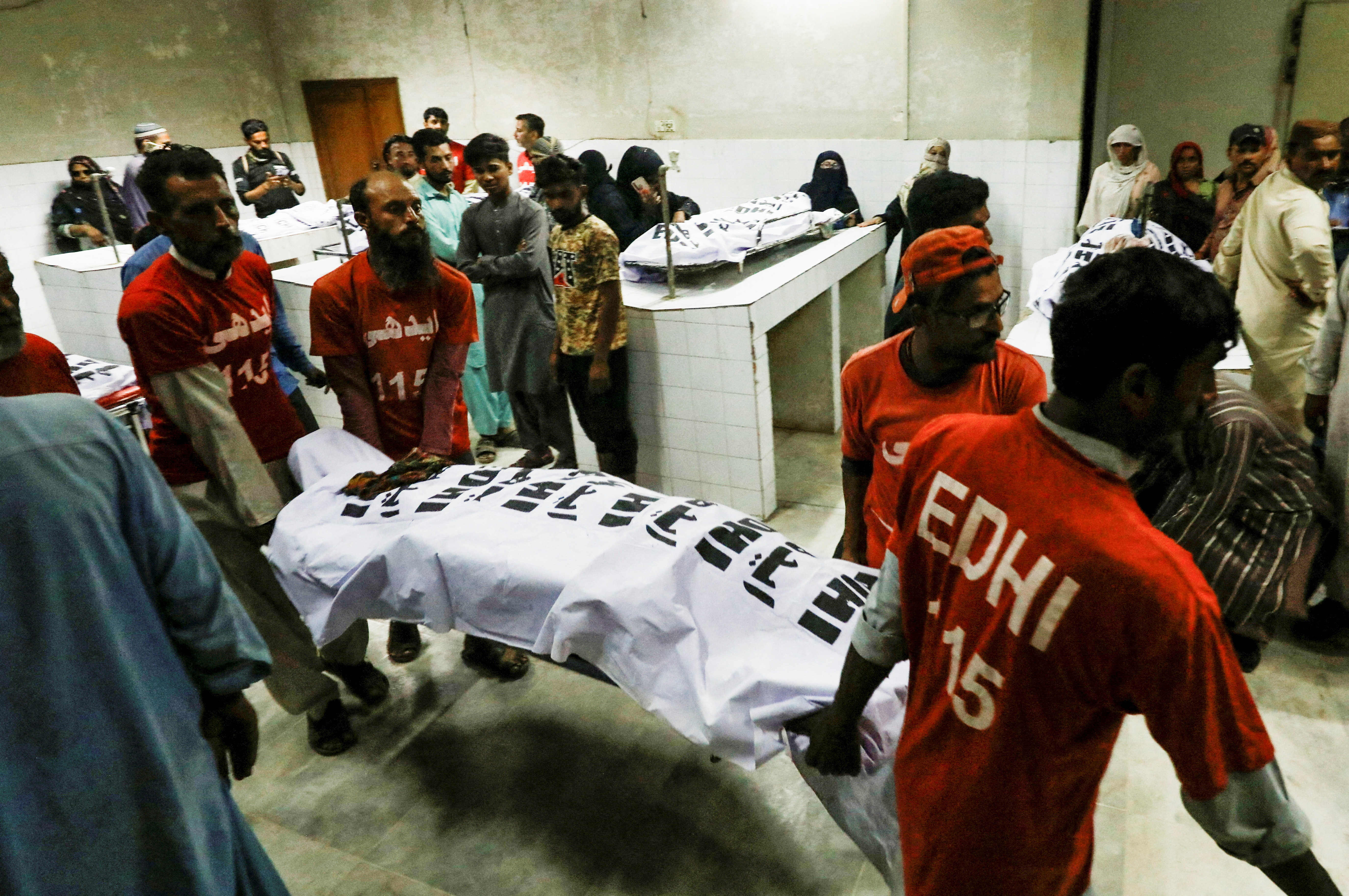Rescue workers move the body of a victim, who was killed along with others in a stampede during handout distribution, at a hospital morgue in Karachi, Pakistan March 31, 2023. REUTERS/Akhtar Soomro REFILE - QUALITY REPEAT