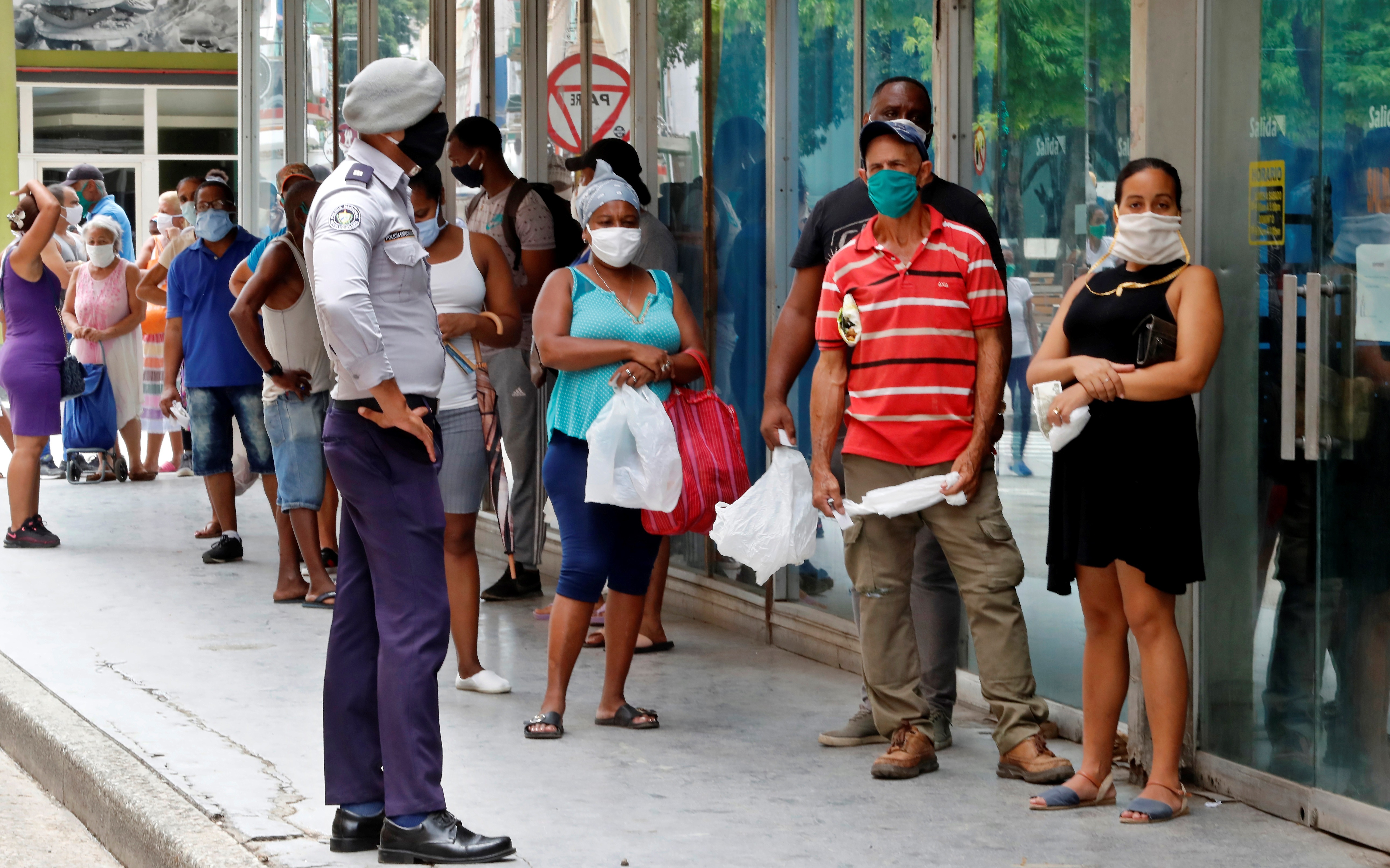 Personas con tapabocas hacen fila afuera de un centro comercial para comprar productos, en La Habana (Cuba), en una fotografía de archivo. EFE/Ernesto Mastrascusa 