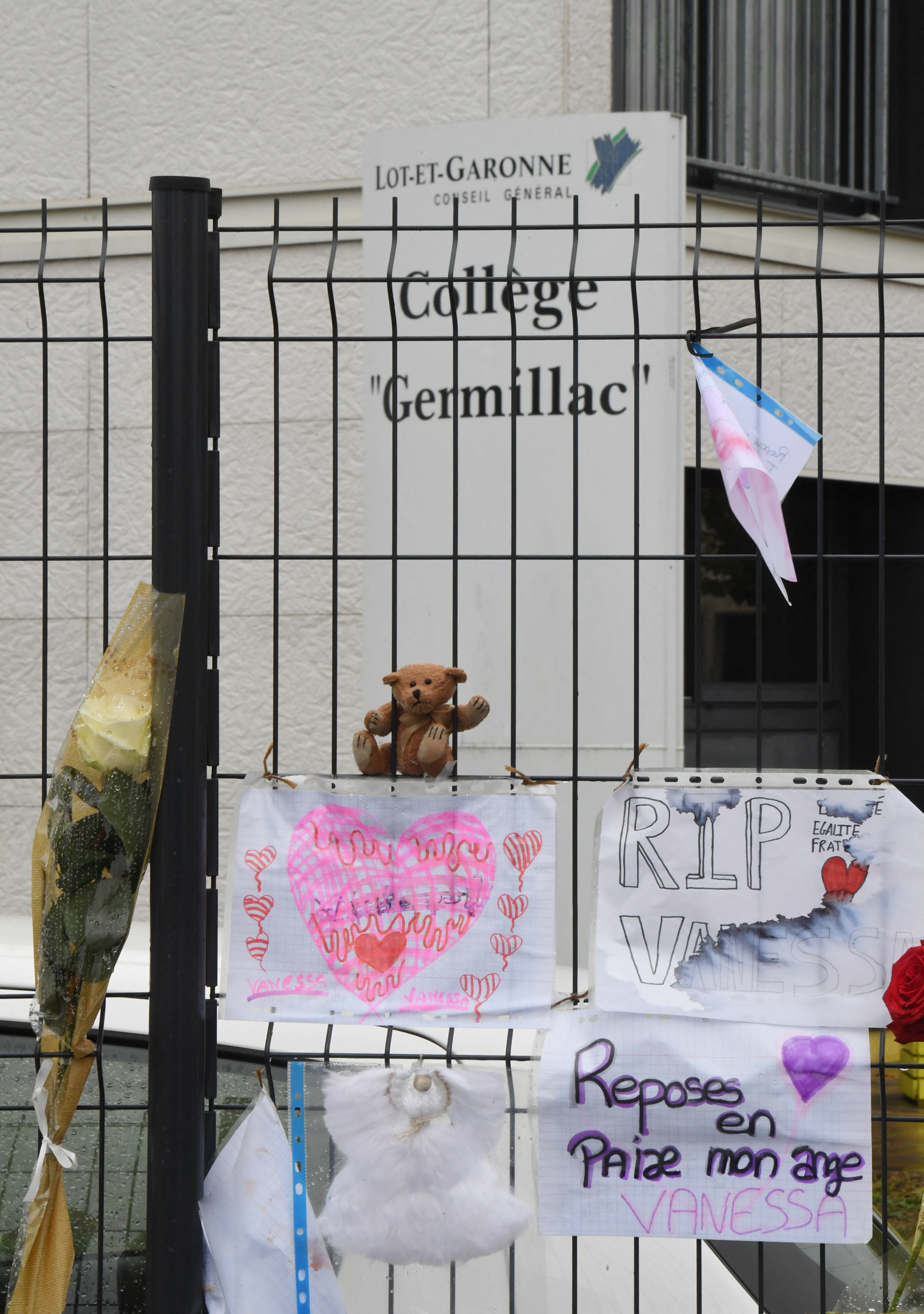 Una foto muestra flores, dibujos y mensajes en las puertas del Germillac College el 21 de noviembre de 2022 en Tonneins, suroeste de Francia, luego de que una niña de 14 años fuera secuestrada afuera de la escuela y encontrada muerta en una casa abandonada (Photo by MEHDI FEDOUACH / AFP)
