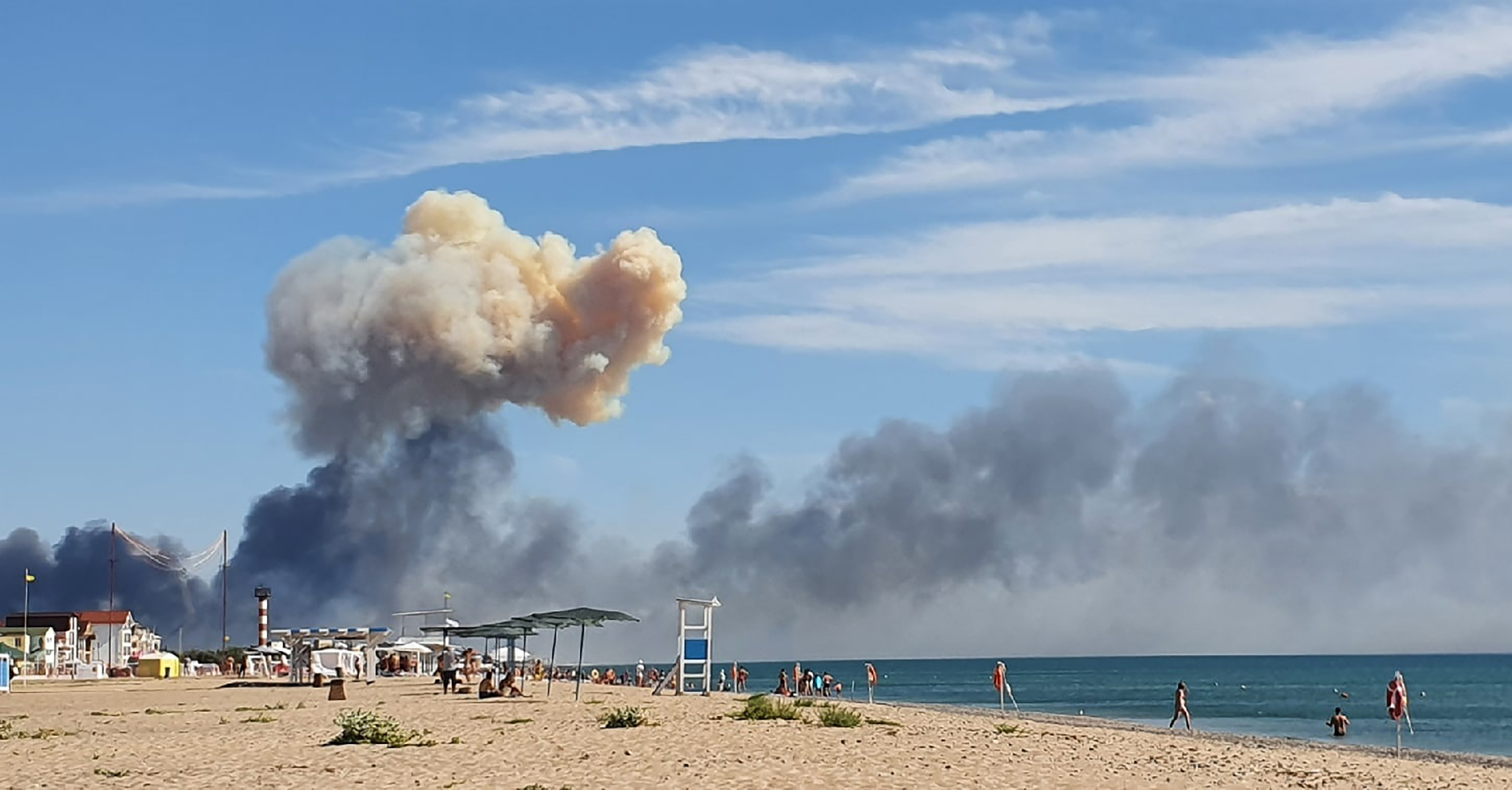 El humo ascendente se puede ver desde la playa de Saky después de que se escucharan explosiones desde la dirección de una base aérea militar rusa cerca de Novofedorivka, Crimea, martes 9 de agosto de 2022. (UGC vía AP)