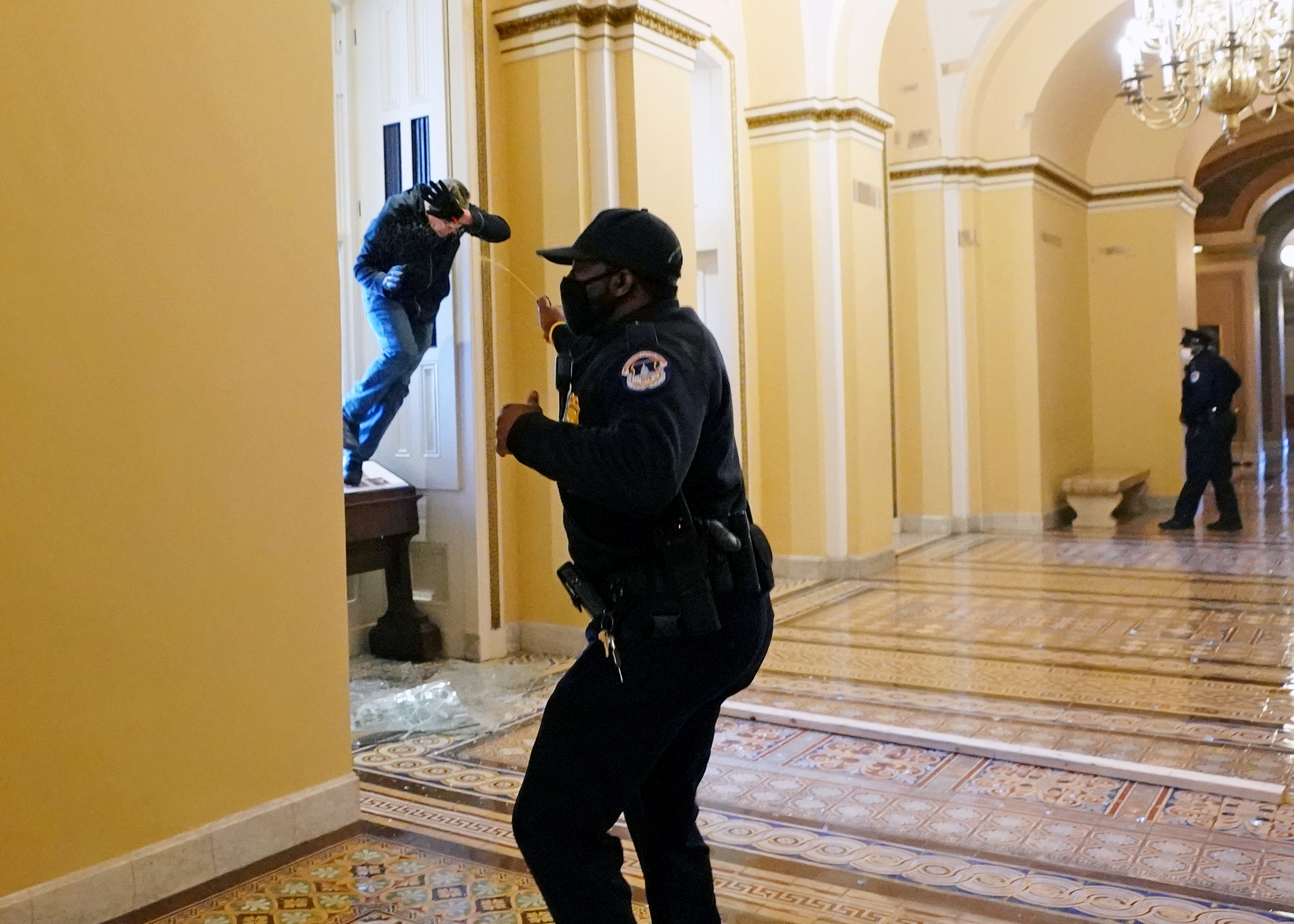 Un oficial de policía tira gas pimienta a un partidario de Trump dentro del Capitolio. Foto: Kevin Dietsch/Pool via REUTERS