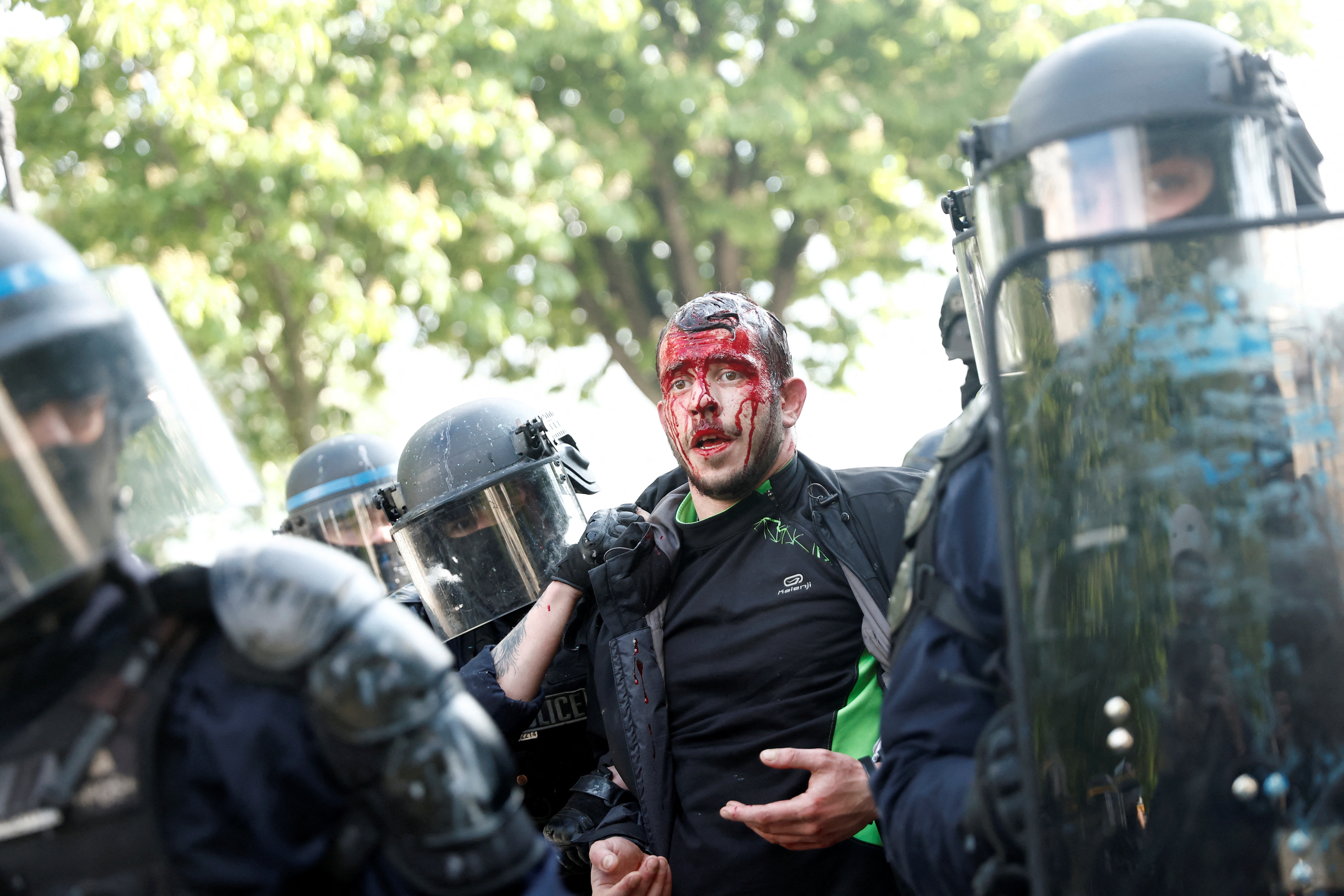 SENSITIVE MATERIAL. THIS IMAGE MAY OFFEND OR DISTURB    French riot police officers walk with a wounded man during the traditional May Day labour march, a day of mobilisation against the French pension reform law and for social justice, in Paris, France May 1, 2023. REUTERS/Benoit Tessier
