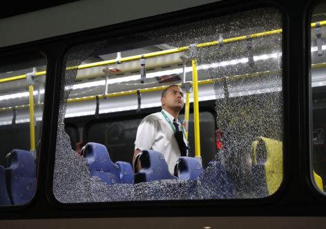 TOPSHOT - The damages to the windows of an Olympic journalists bus hit while driving on the transolympica highway are inspected by an official in Rio de Janeiro on August 9, 2016. 
- Argentina OUT - LA NACION    / AFP / LA NACION / Maximiliano AMENA / Argentina OUT        (Photo credit should read MAXIMILIANO AMENA/LA NACION//AFP/Getty Images)