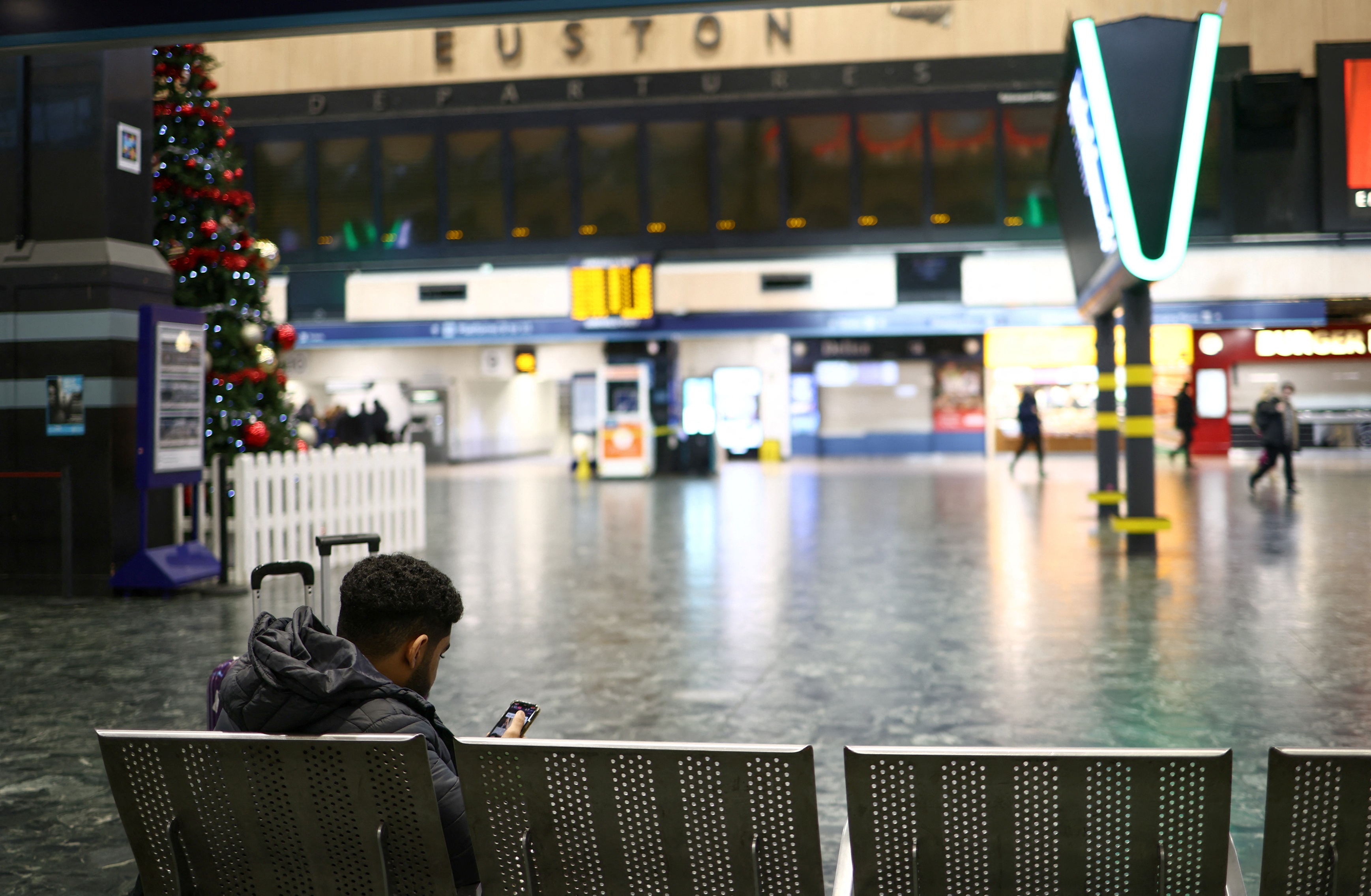 A person sits in a waiting room inside Euston station, as railway workers strike members of the ASLEF union in London, Britain, January 5, 2023. REUTERS/Henry Nicholls