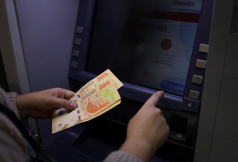 File Photo: - A woman withdraws Argentine pesos from an ATM in Buenos Aires, Argentina.  May 23, 2022. REUTERS/Cristina Sille