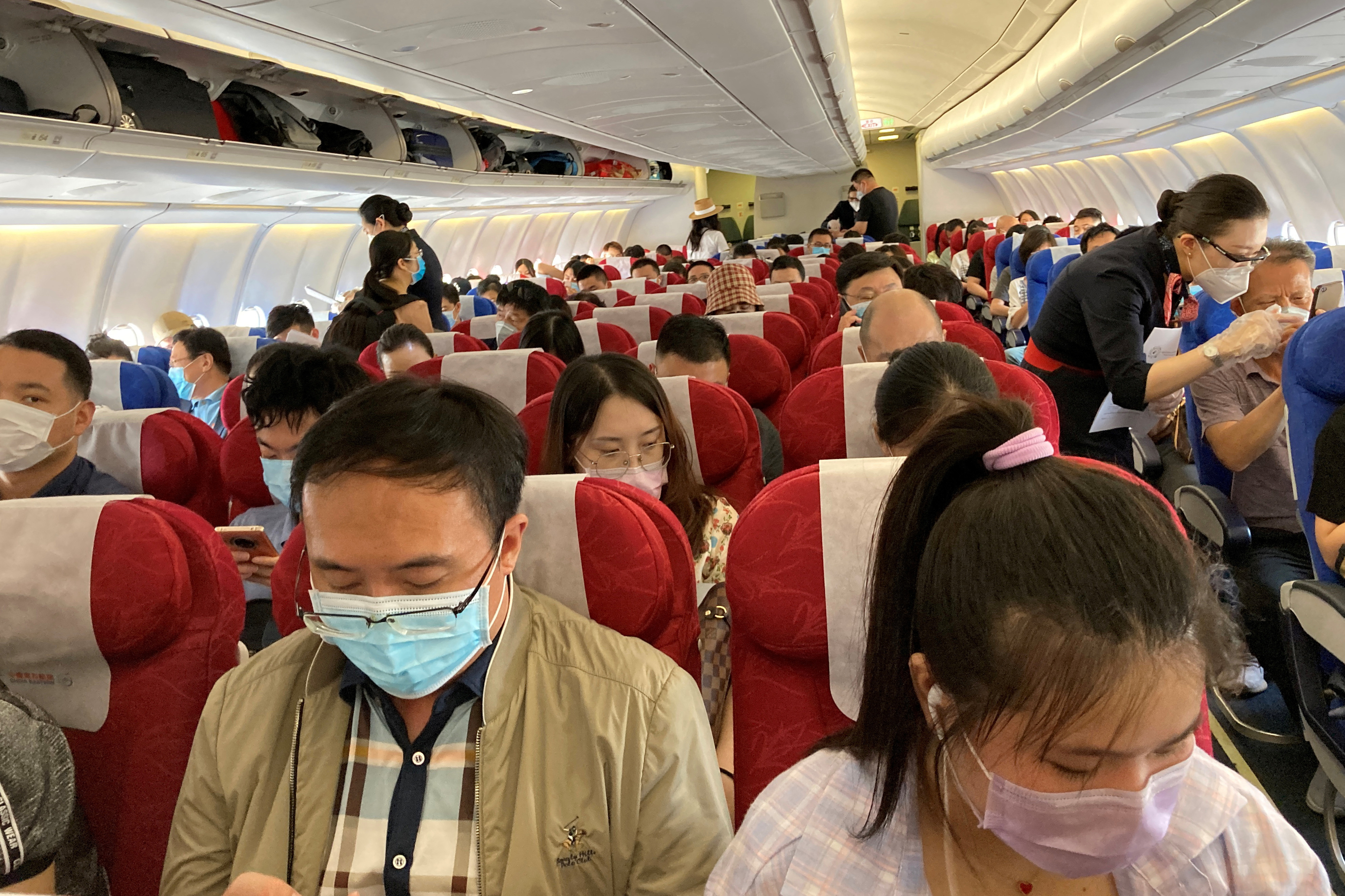 Pasajeros con mascarillas tras el brote de la enfermedad por coronavirus (COVID-19) en un vuelo de China Eastern Airlines en el Aeropuerto Internacional de Shenzhen Baoan en Shenzhen, provincia de Guangdong, China 19 de mayo de 2020. REUTERS/Martin Pollard/Archivo