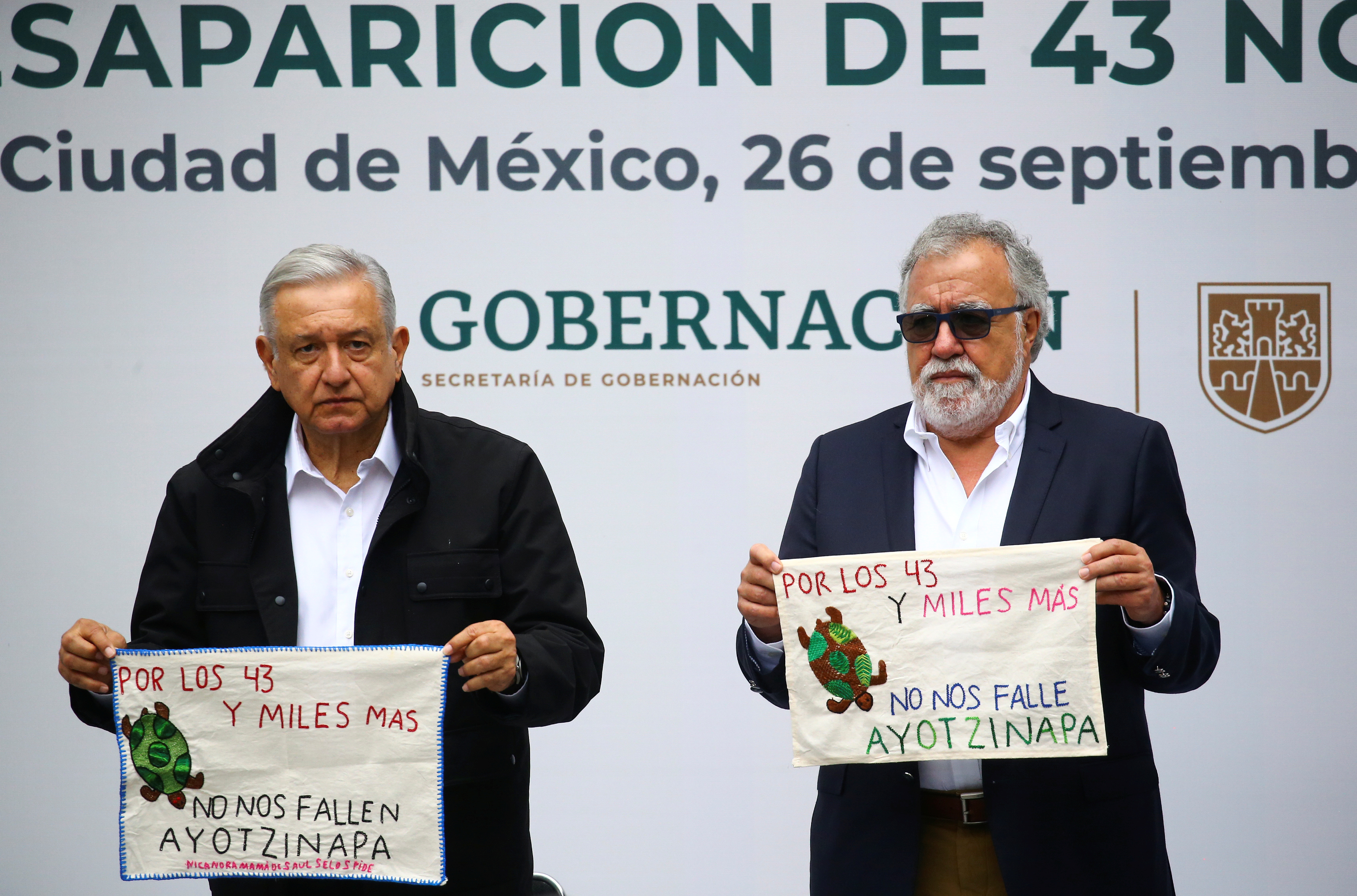 Mexico's President Andres Manuel Lopez Obrador and Mexico's Undersecretary of Human Rights Alejandro Encinas hold pieces of fabric embroidered by relatives of the 43 missing students of the Ayotzinapa Teacher Training College, as they attend the delivery of an investigation report with marking the 6th anniversary of their disappearance, at the National Palace in Mexico City, Mexico September 26, 2020. REUTERS/Edgard Garrido