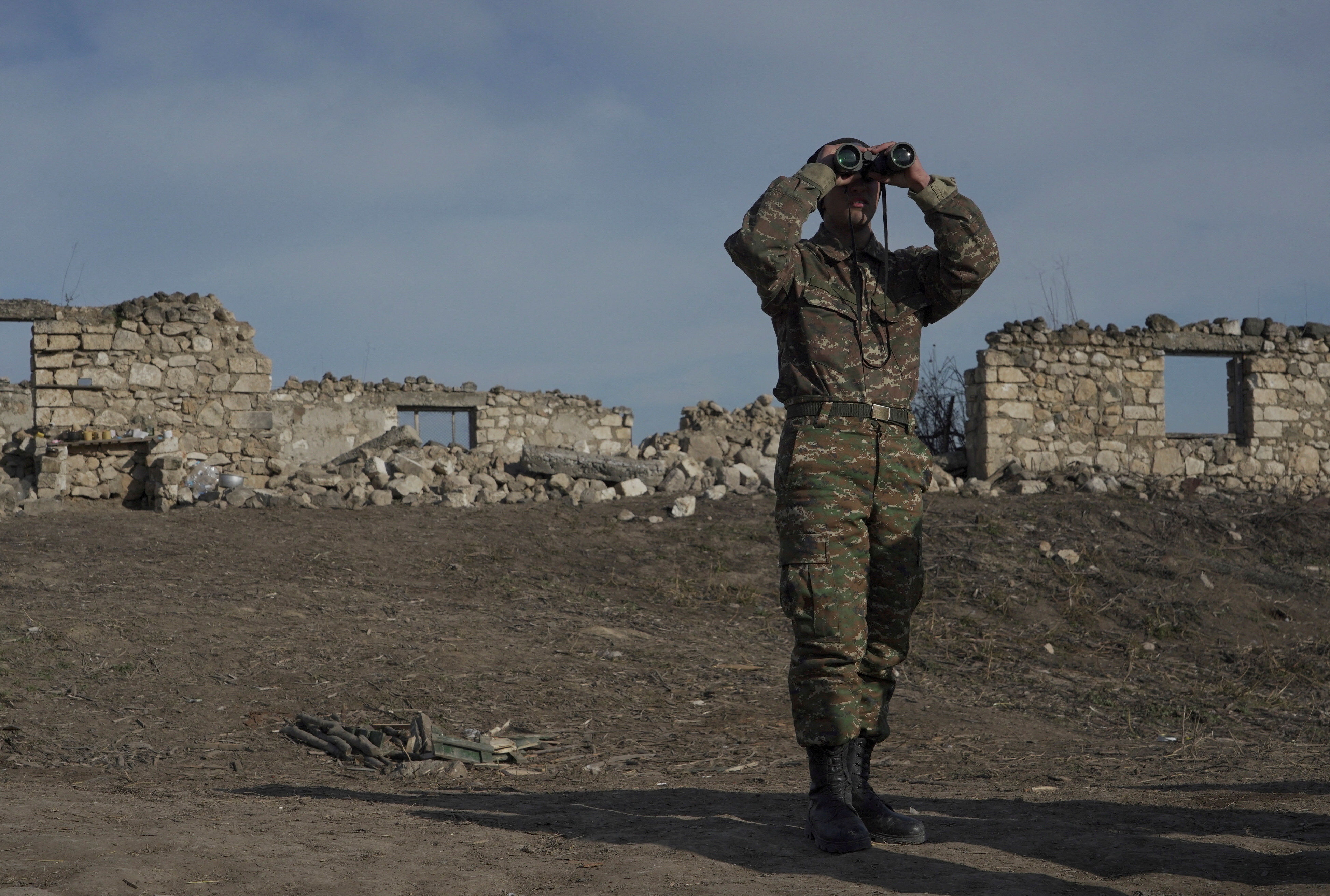 Un soldado de etnia armenia mira a través de unos prismáticos mientras se encuentra en las posiciones de combate cerca de la aldea de Taghavard, en la región de Nagorno-Karabaj, 11 de enero de 2021. Fotografía tomada el 11 de enero de 2021. REUTERS/Artem Mikryukov/Archivo