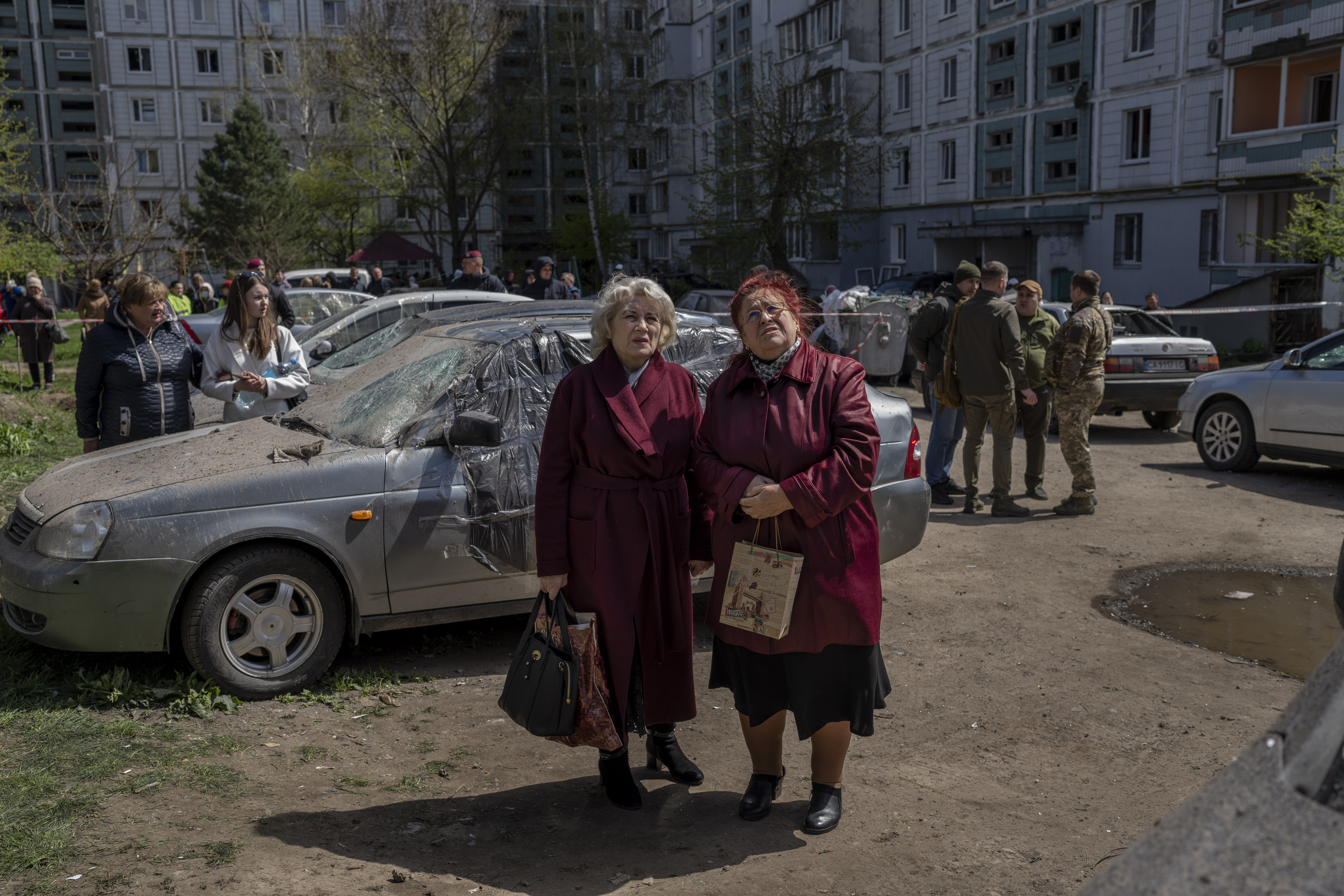 Residentes observan la destrucción de un edificio residencial que fue alcanzado durante un ataque ruso en Uman, Ucrania central, el viernes 28 de abril de 2023. (AP Photo/Bernat Armangue)