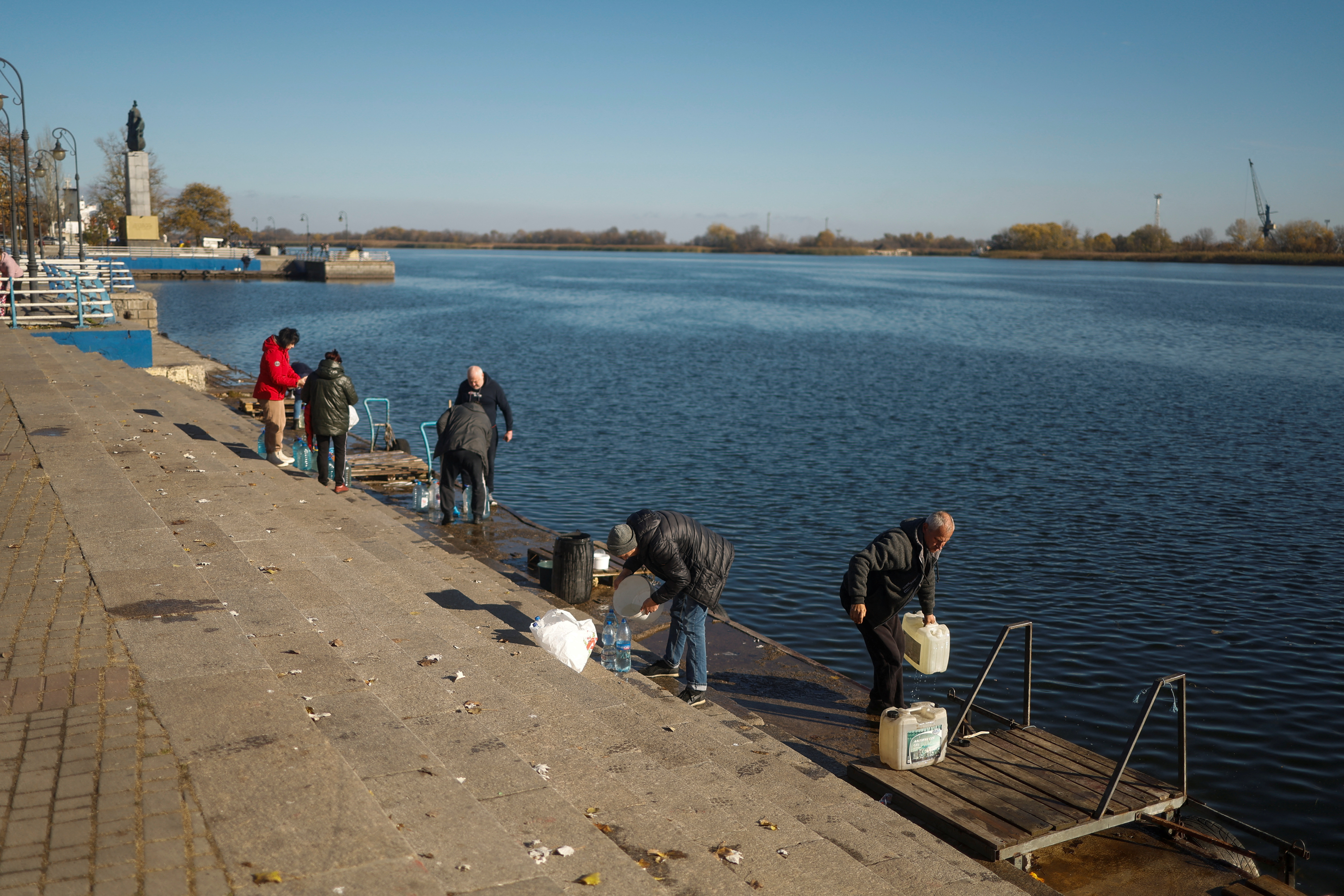 Ciudadanos llenan botellas con agua del río en Kherson (REUTERS/Valentyn Ogirenko)