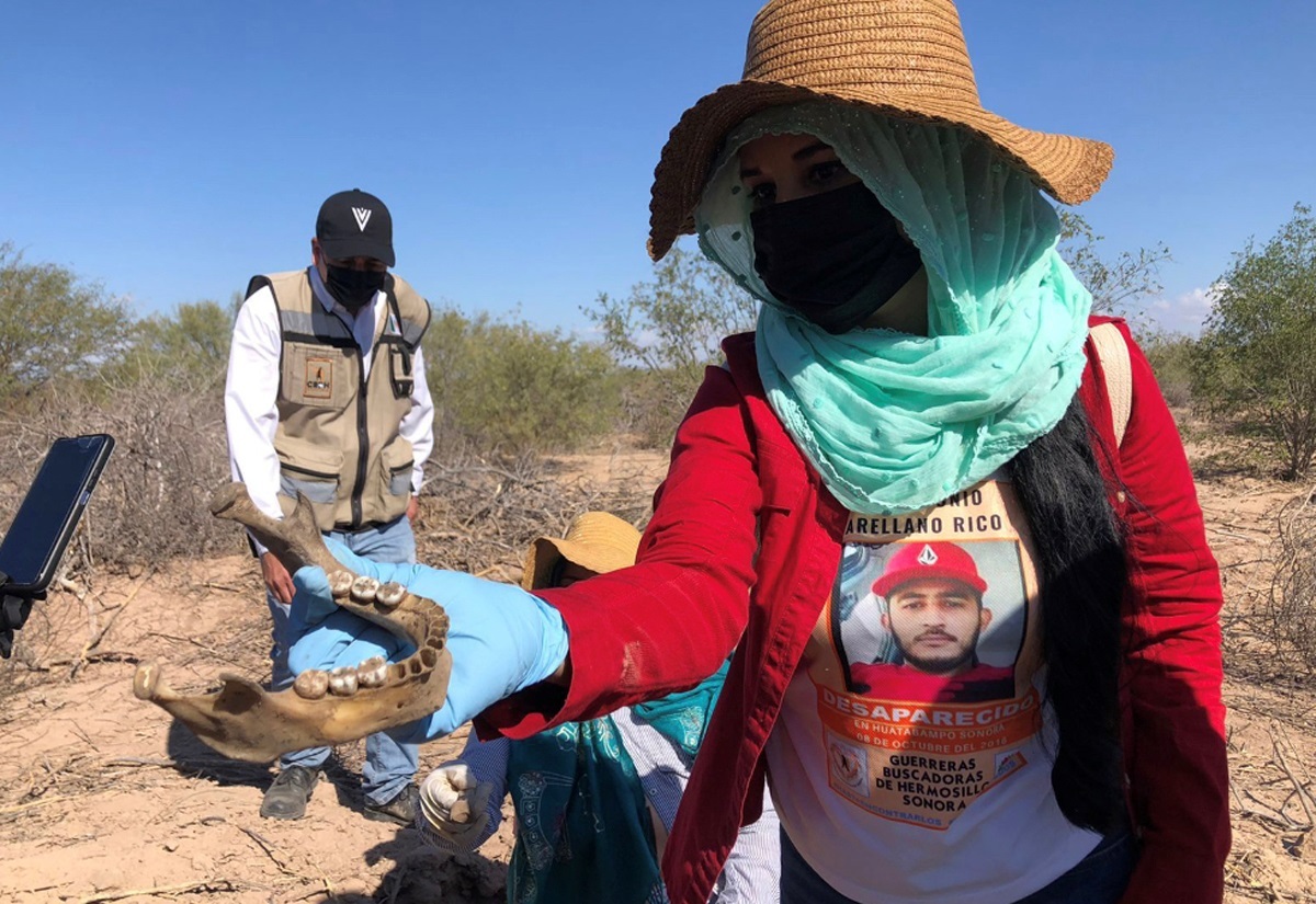 Una mujer que pertenece a la ONG Madres Buscadoras muestra restos humanos localizados en una fosa clandestina, el 24 de noviembre de 2021, en Hermosillo (México). EFE/ Daniel Sánchez 