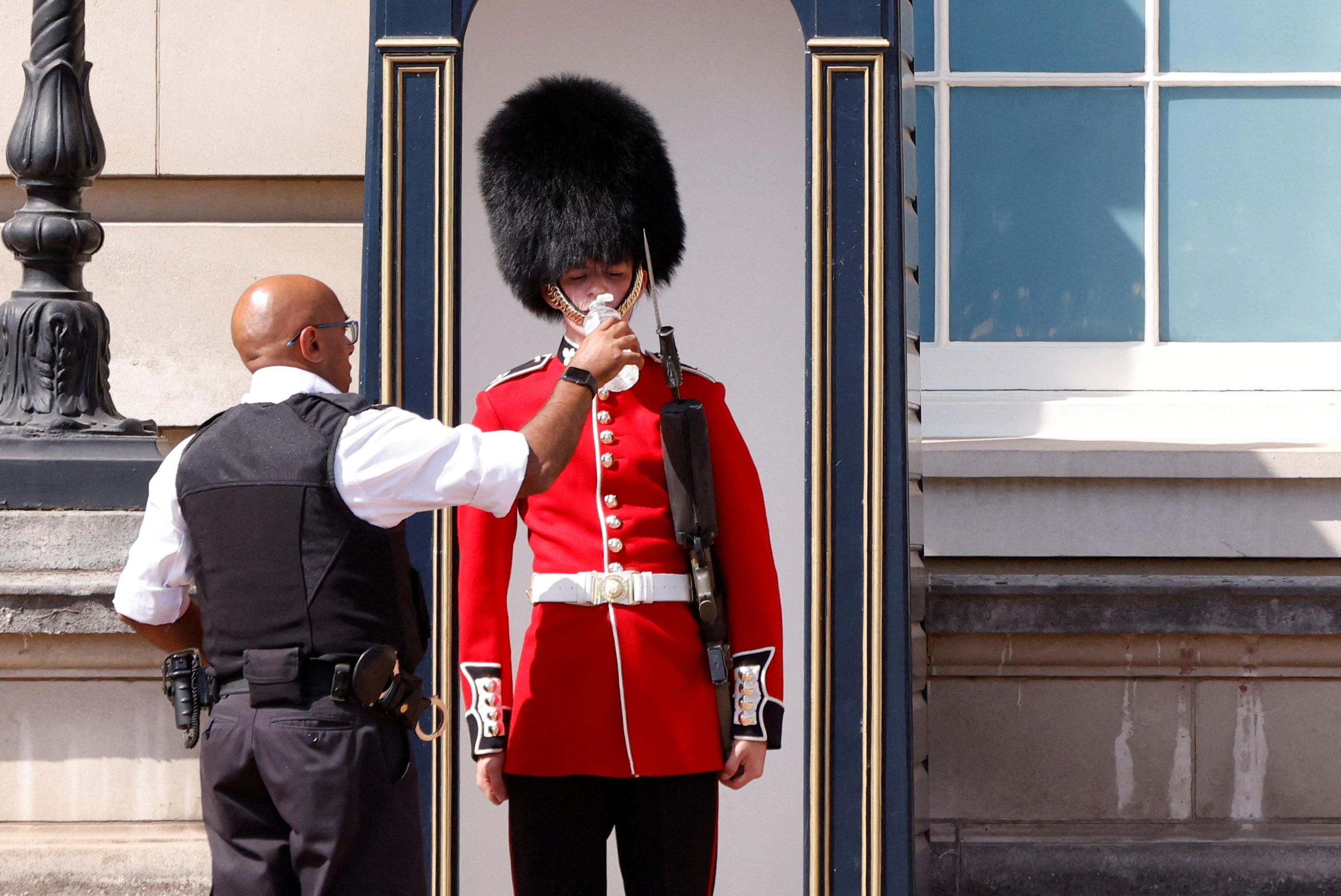 Un miembro de la Guardia de la Reina recibe agua para beber durante la ola de calor, en las afueras del Palacio de Buckingham en Londres (REUTERS/John Sibley)