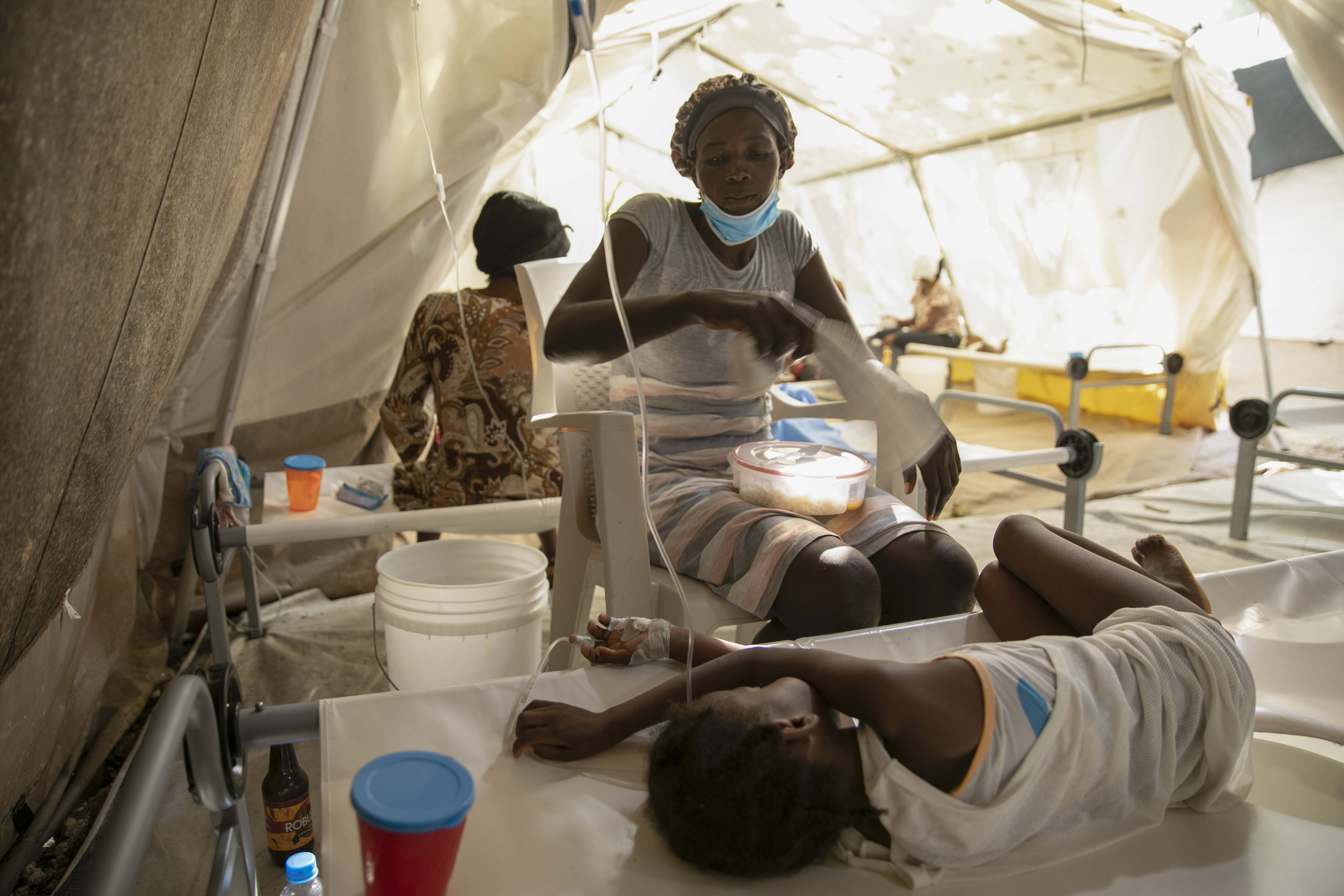 Una mujer usa una toalla para espantar las moscas de su hija enferma de cólera, en una clínica administrada por Médicos Sin Fronteras en Puerto Príncipe, Haití, el viernes 11 de noviembre de 2022. (Foto AP/Odelyn Joseph)
