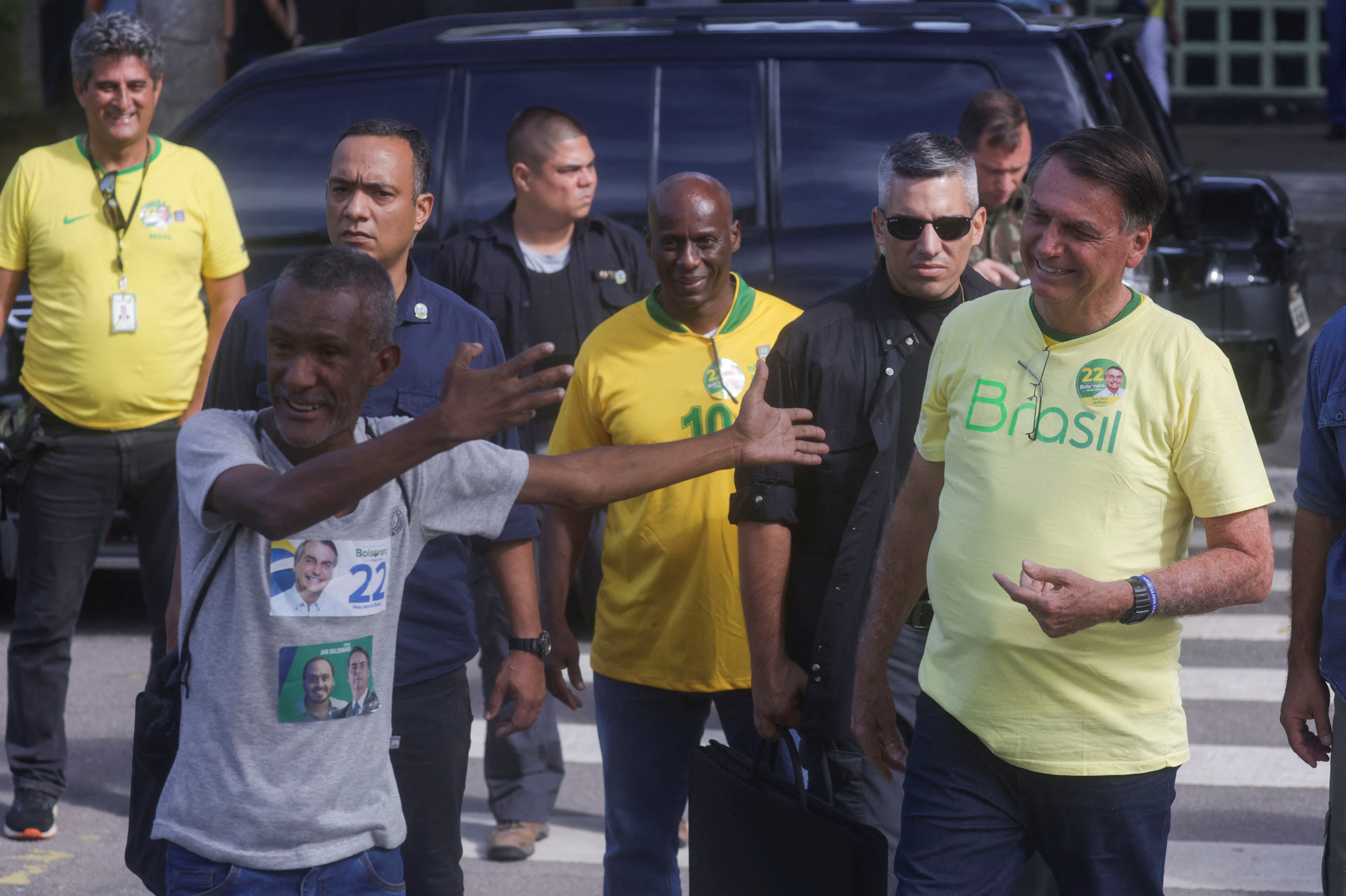 Bolsonaro sonríe junto a uno de sus simpatizantes afuera del centro de votación (Reuters)