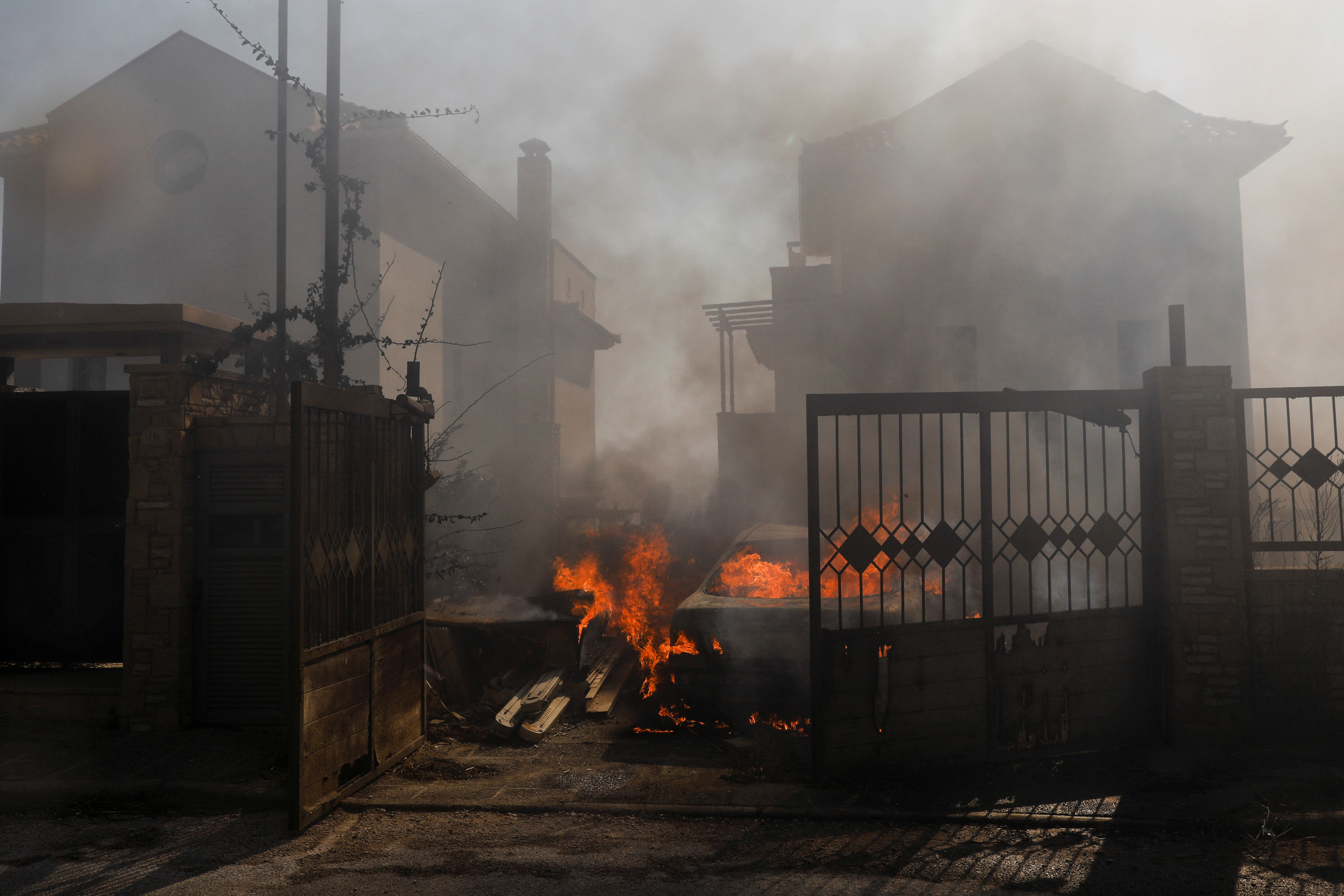Un automóvil envuelto en llamas en una casa de Pallini, cerca de Athens (REUTERS/Costas Baltas)