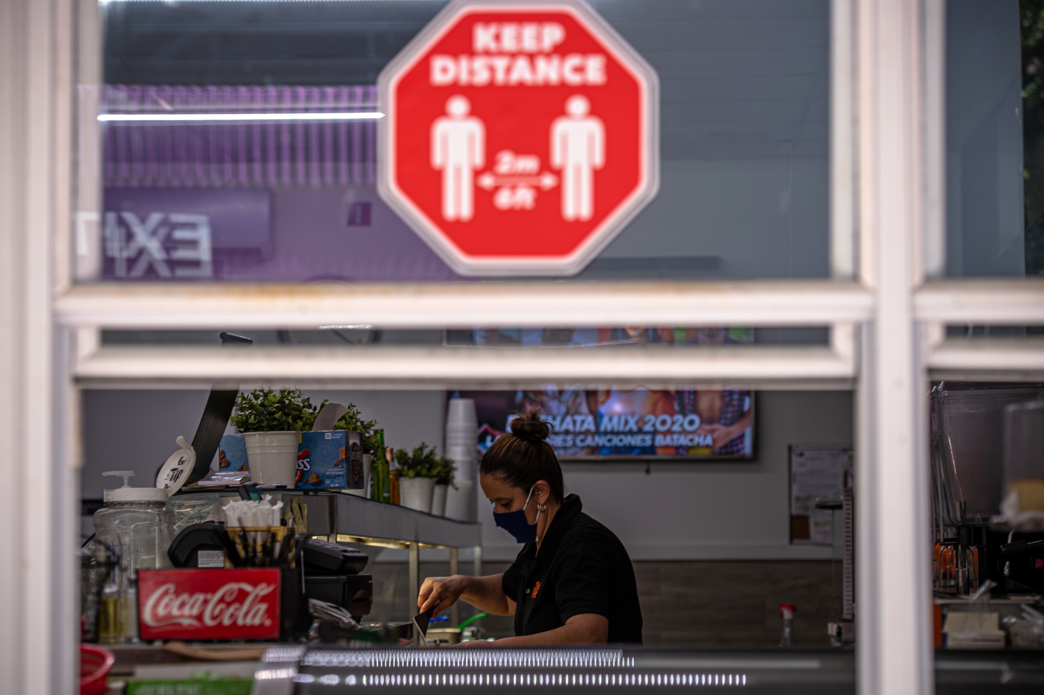 Fotografía de archivo que muestra a una mujer mientras trabaja en un local de comida que solo sirve por ventana debido a la pandemia del coronavirus, en Miami, Florida (EE.UU). EFE/Giorgio Viera/Archivo

