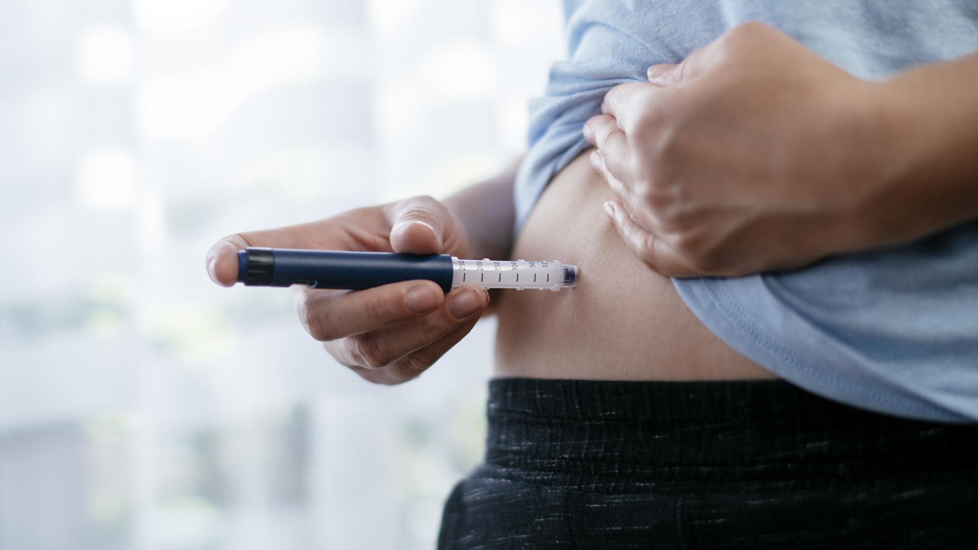Woman is making insulin injection in the stomach. Stock photo  Shadow DOF. Developed from RAW; retouched with special care and attention; Small amount of grain added for best final impression. 16 bit Adobe RGB color profile.