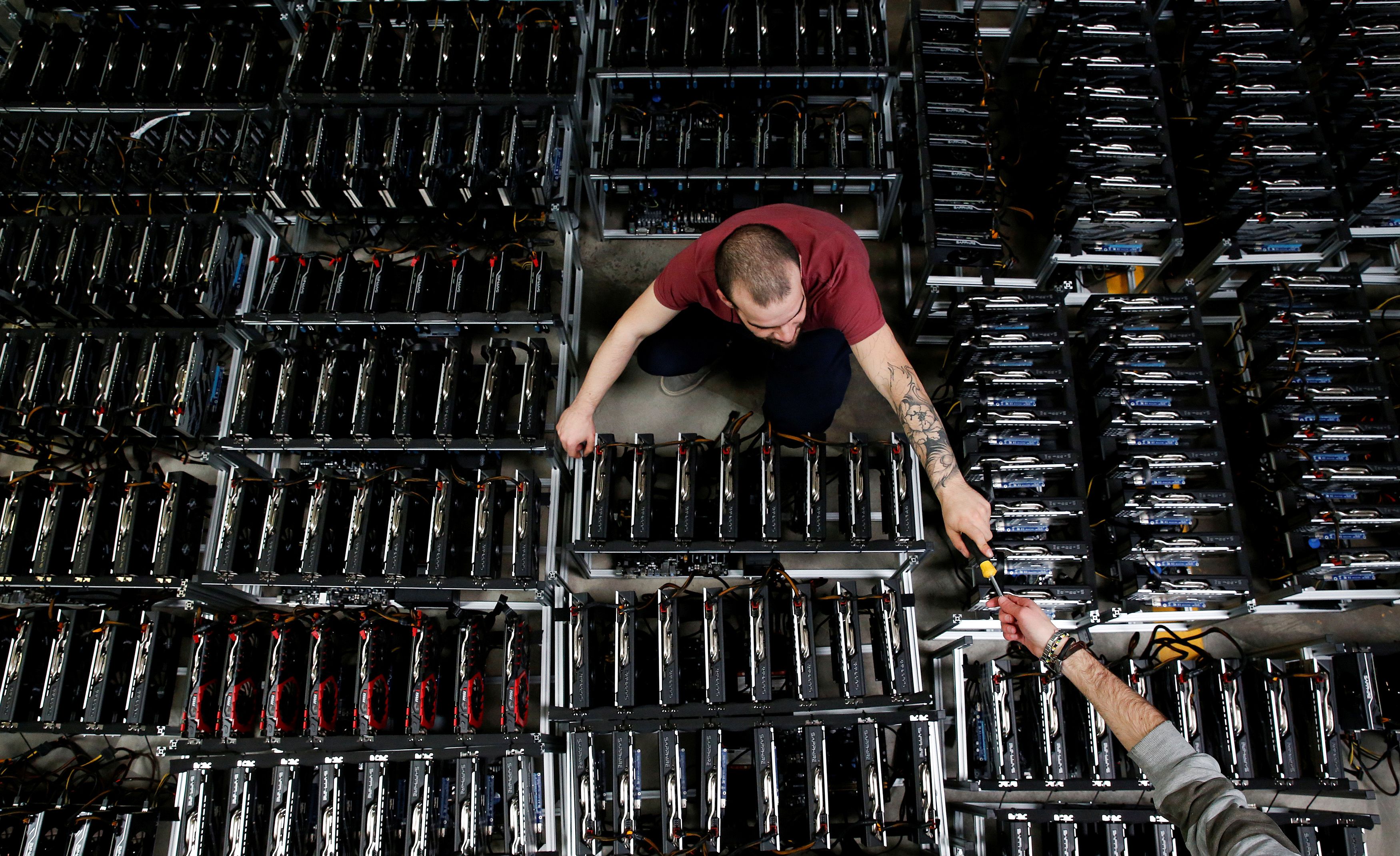 FOTO DE ARCHIVO: Empleados trabajan en computadoras de minería de bitcoin en Florencia, Italia, el 6 de abril de 2018 (REUTERS/Alessandro Bianchi)