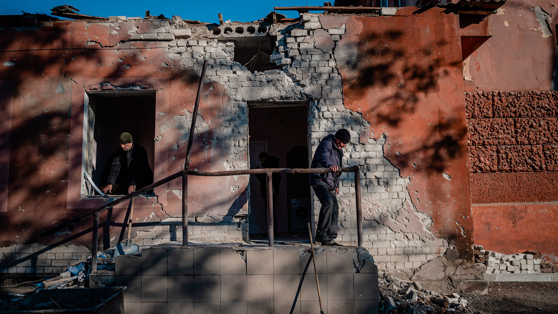 Trabajadores limpian los escombros tras el bombardeo ruso de la unidad de maternidad de un hospital en Kherson, al sur de Ucrania, el 28 de diciembre de 2022. (Fotografía de Dimitar DILKOFF / AFP)
