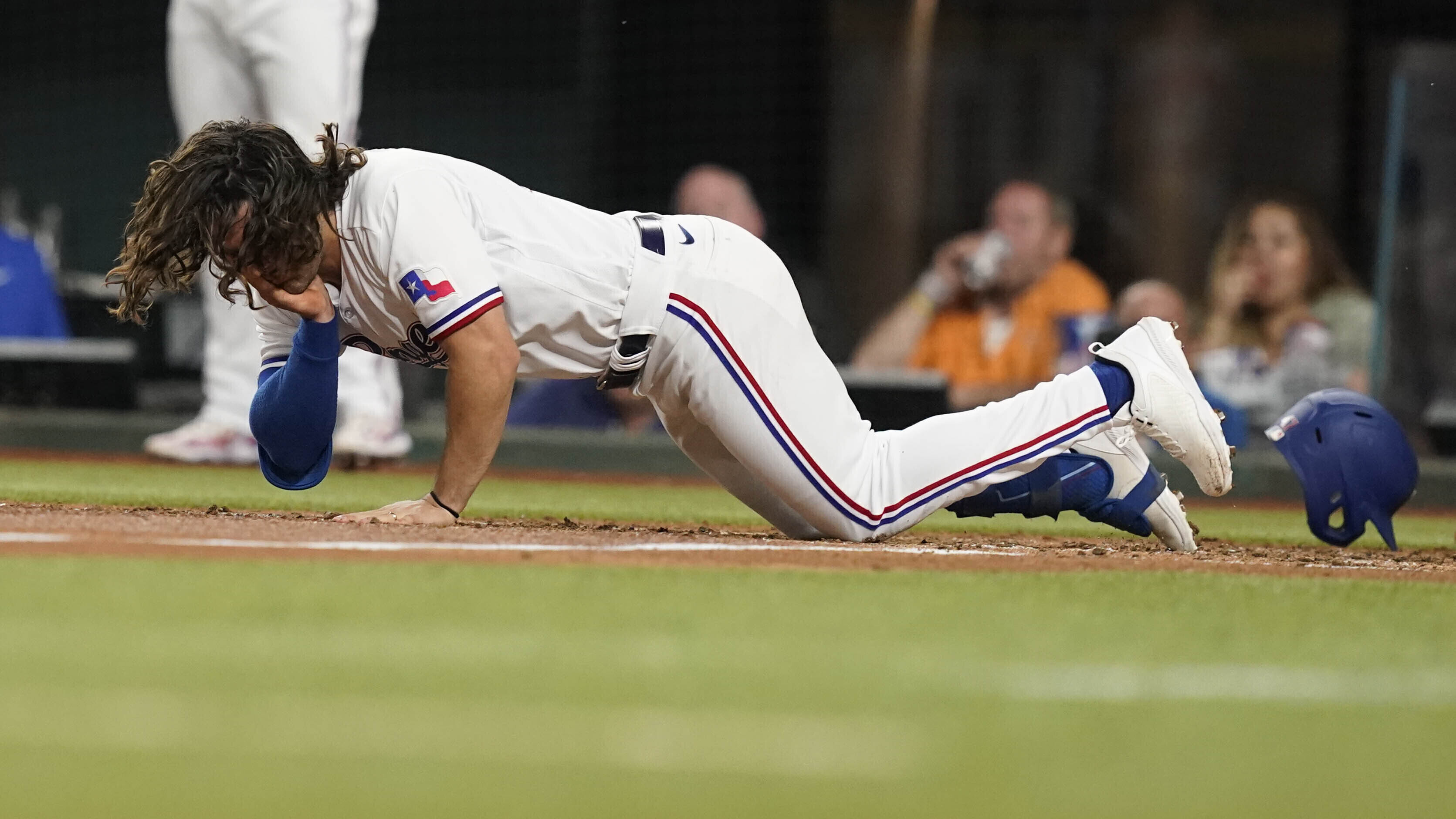 Josh Smith of the Texas Rangers falls after being hit in the face by a pitch during the third inning of a baseball game against the Baltimore Orioles in Arlington, Texas, Monday, April 3, 2023. (AP Photo/LM Otero)