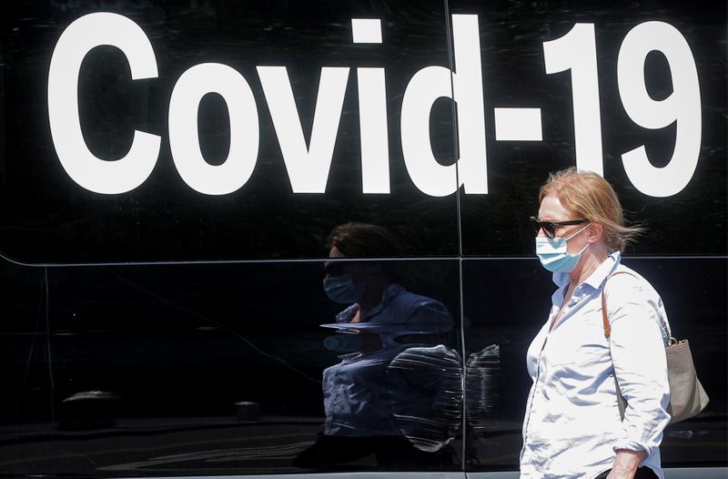 Una mujer con mascarilla pasa junto a una furgoneta de pruebas móviles de la enfermedad por coronavirus, en el parque de Washington Square en Nueva York, Estados Unidos, 22 de julio de 2021.  REUTERS/Brendan McDermid