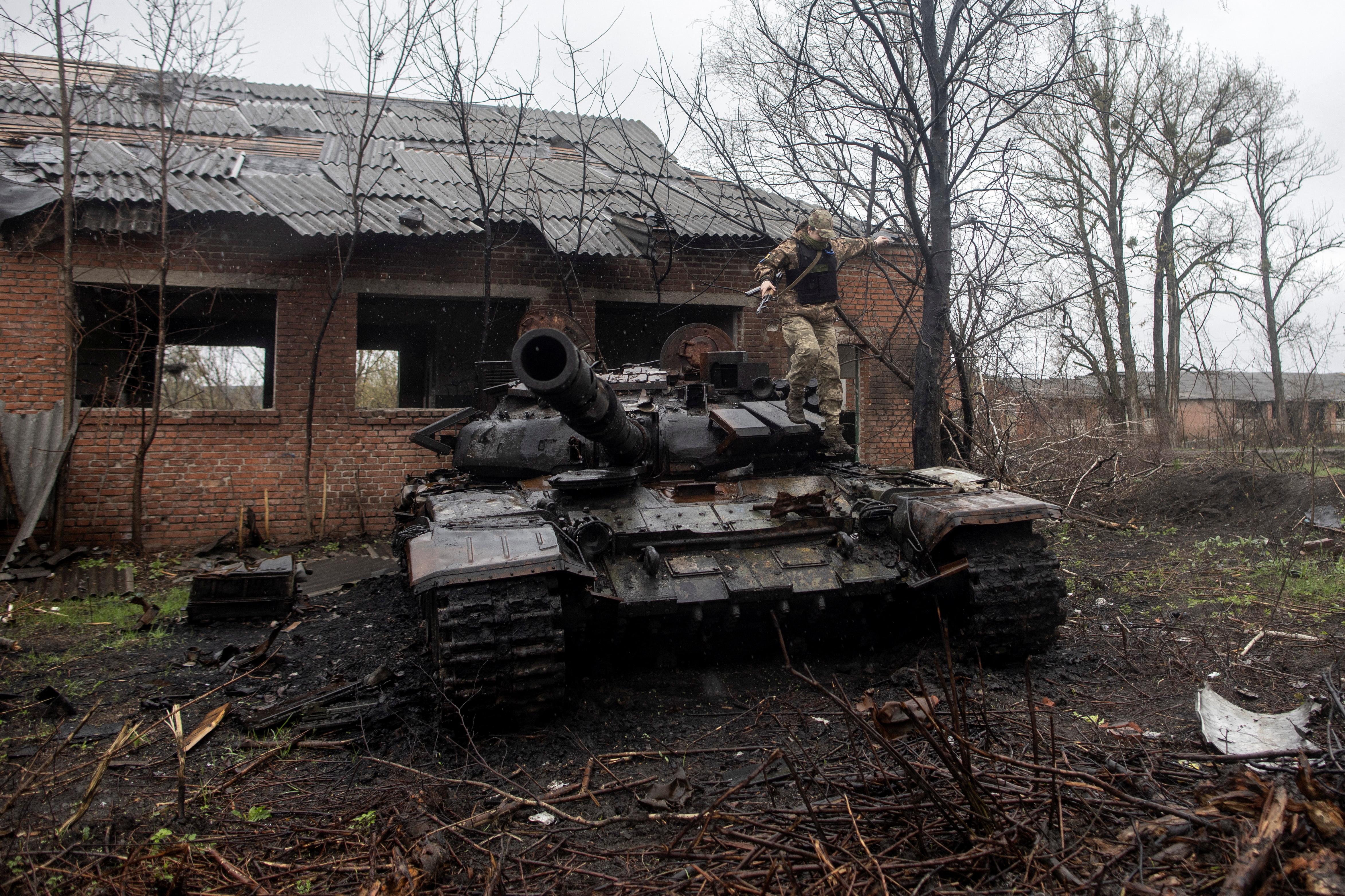 Un soldado ucraniano salta sobre un tanque ruso destruido en Kharkiv (REUTERS/Alkis Konstantinidis)