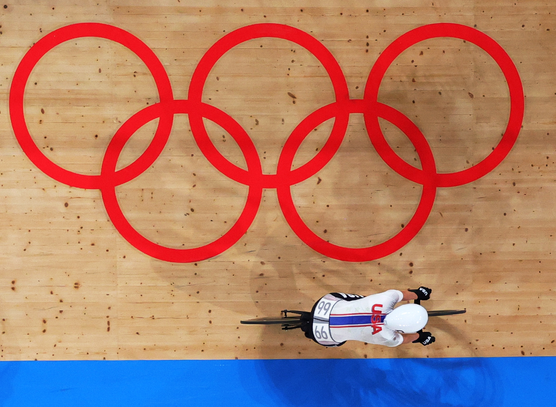 Tokyo 2020 Olympics - Cycling - Track - Women's Omnium - Points Race - Izu Velodrome, Shizuoka, Japan - August 8, 2021. Jennifer Valente of the United States cycles past the Olympic rings. REUTERS/Christian Hartmann