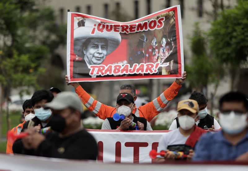 Trabajadores de la mina Las Bambas sostienen una pancarta con una imagen del presidente de Perú, Pedro Castillo, durante una protesta contra el bloqueo a la mina, en Lima, Perú. Foto: REUTERS/Angela Ponce