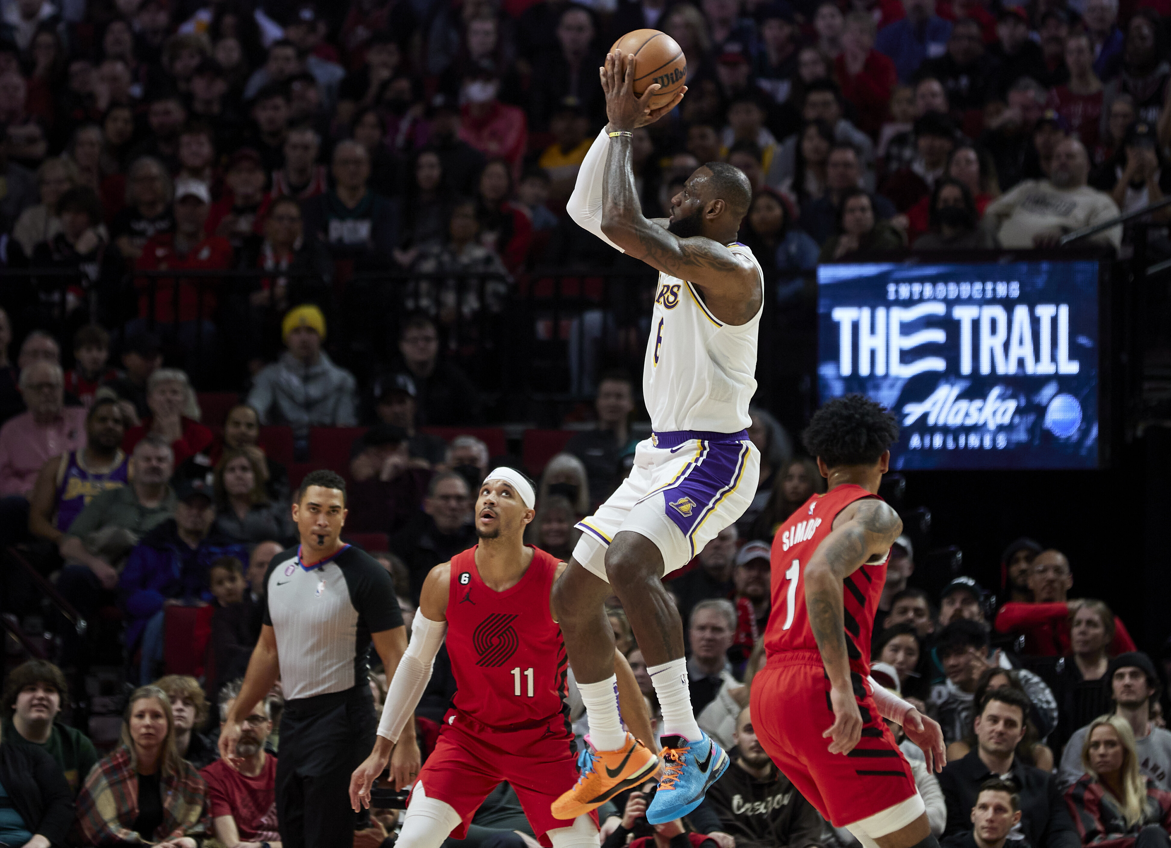 Los Angeles Lakers forward LeBron James jumps in to score on a long-distance goal as Portland Trail Blazers Josh Hart and Infernee Simmons watch in a game Sunday, Jan. 22, 2023. (AP Photo/Craig Mitchelldyer)