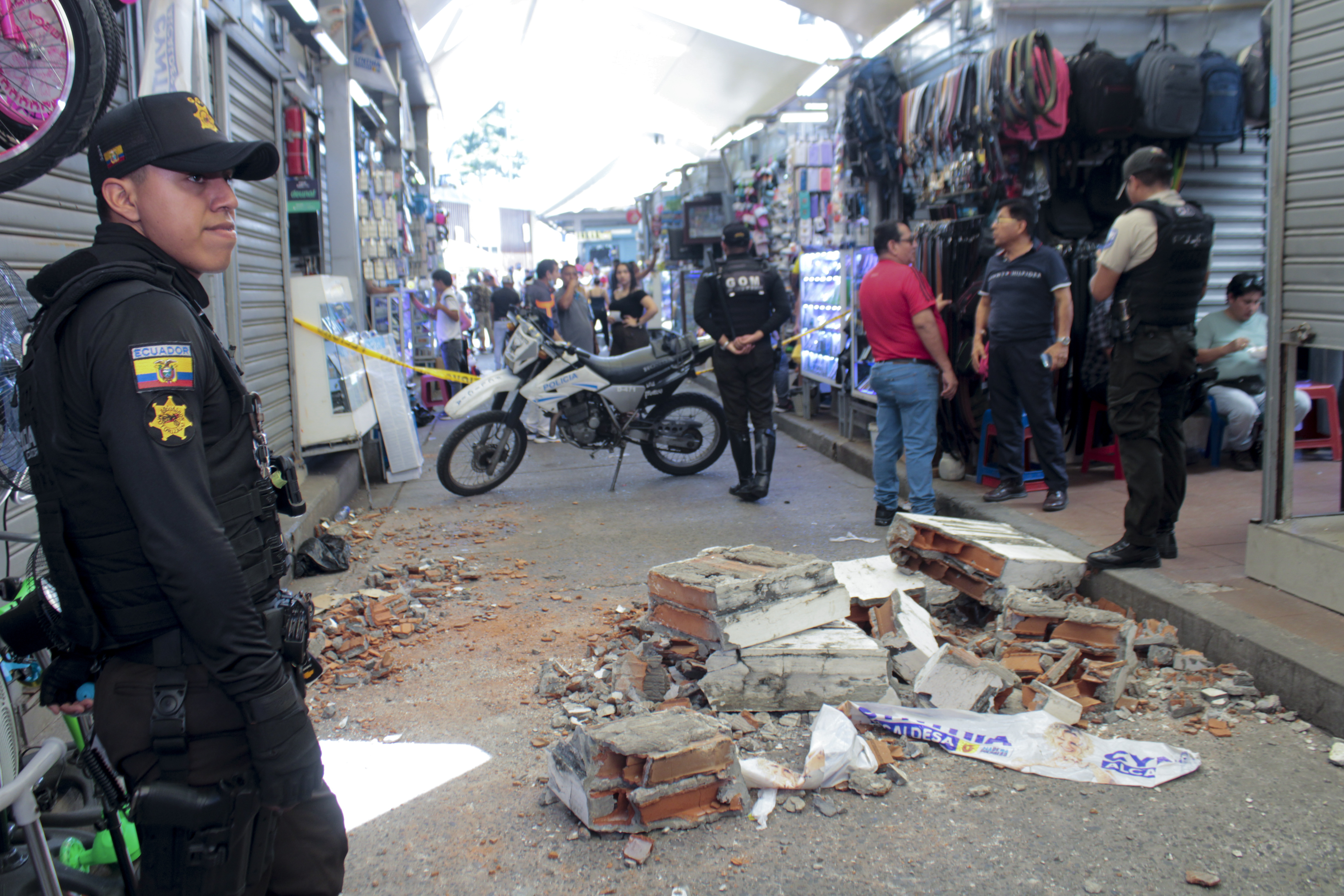 Policías vigilan una calle con escombros caídos de un edificio en un área comercial después de un fuerte terremoto, en Machala, Ecuador, el sábado 18 de marzo de 2023. El Servicio Geológico de EEUU dijo que el sismo de 6,7 se produjo a 50 millas (80 kilómetros) al sur de Guayaquil. (Foto AP/Stalin Díaz)