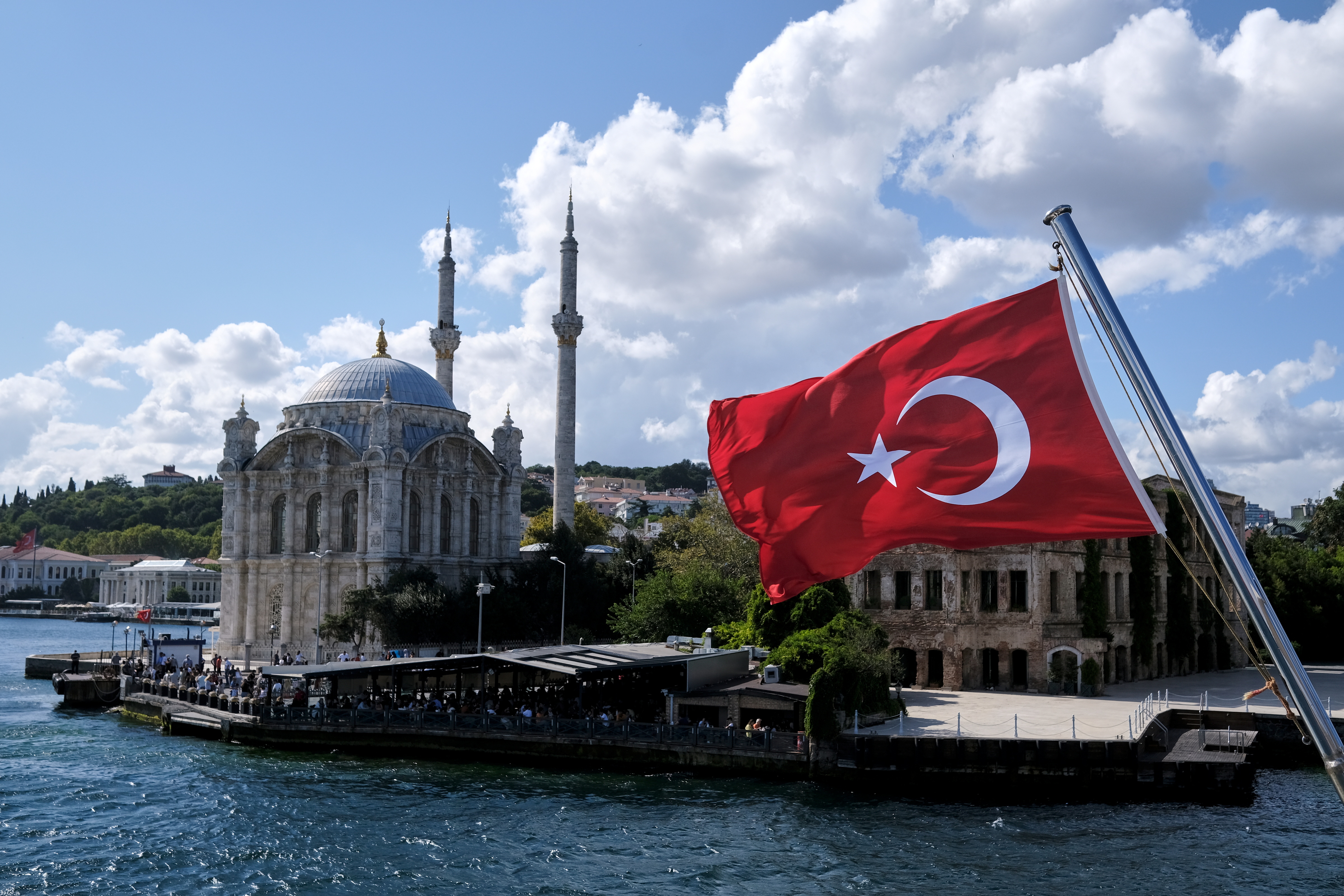 Una bandera turca aparece en un barco con la mezquita de Ortakoy de fondo en Estambul, Türkiye, el 5 de septiembre de 2021. REUTERS/Murad Sezer