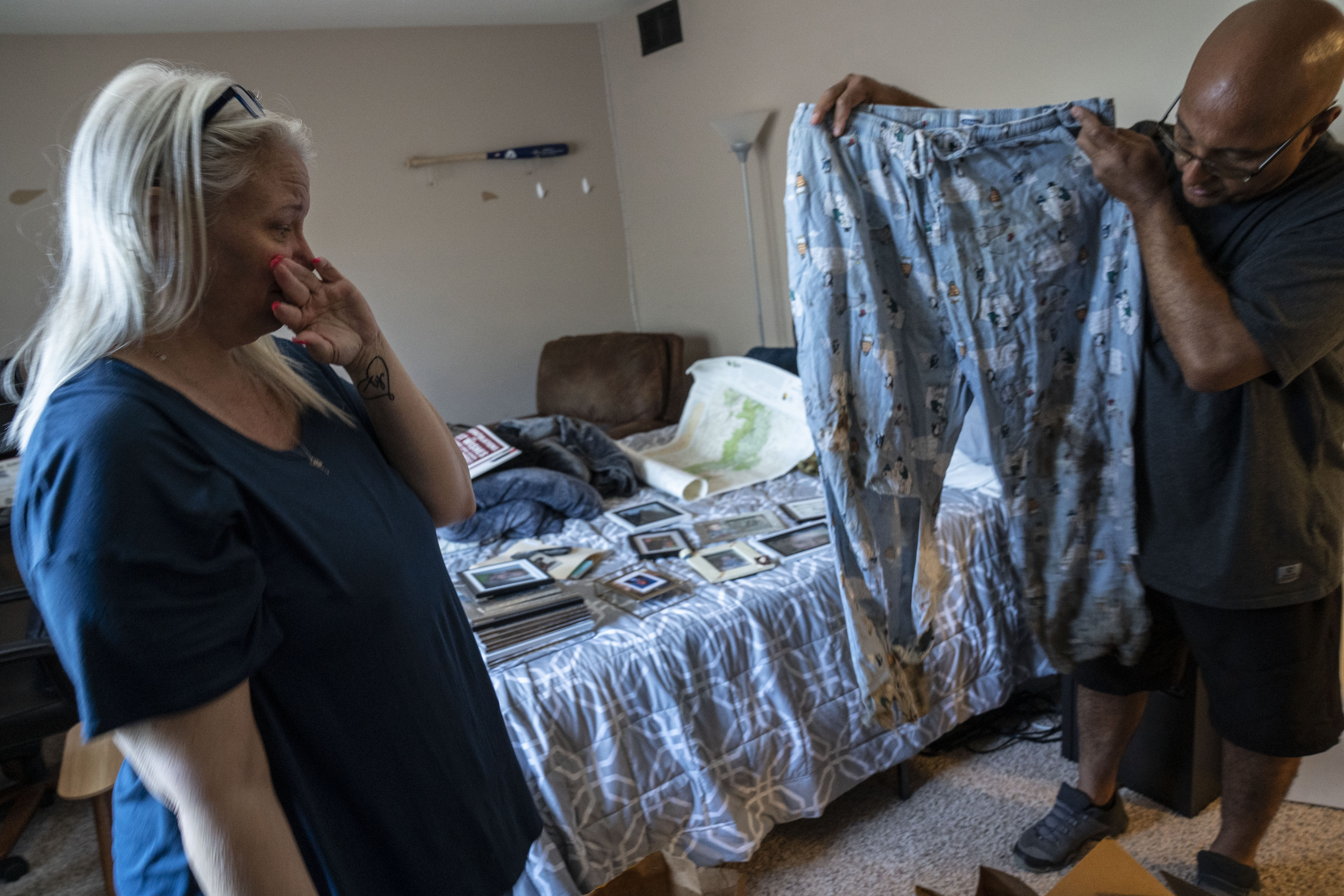 En su casa de Union Beach, Nueva Jersey, el 10 de junio de 2022, Chandra Maxwell y su marido John Sauer miran los pantalones de pijama que llevaba su hijo Ty Sauer cuando desapareció en el Parque Nacional Shenandoah de Virginia en abril de 2021 (The Washington Post)