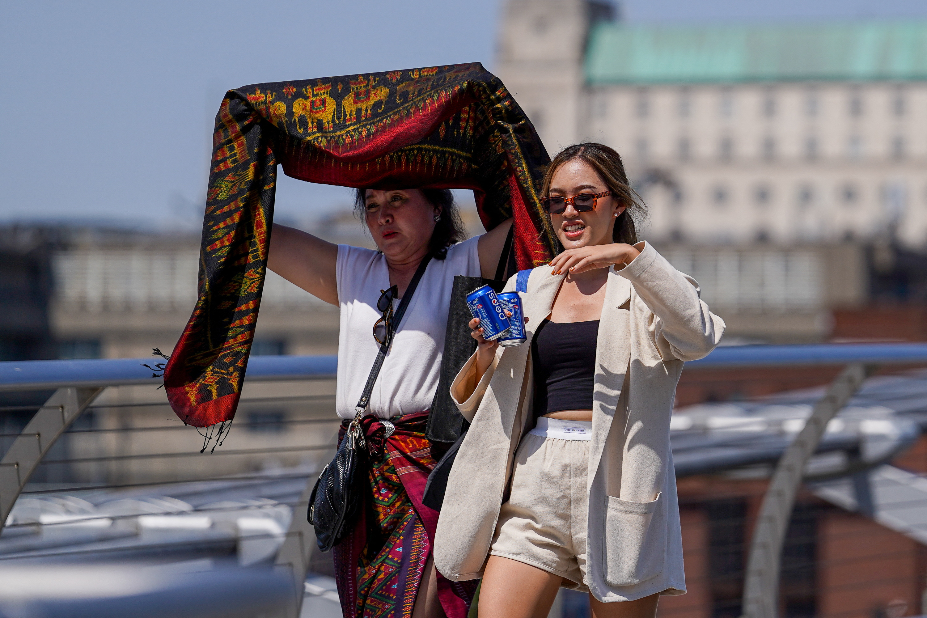 La gente se cubre del sol en el Puente del Milenio durante una ola de calor, en Londres (REUTERS/Maja Smialkowska)